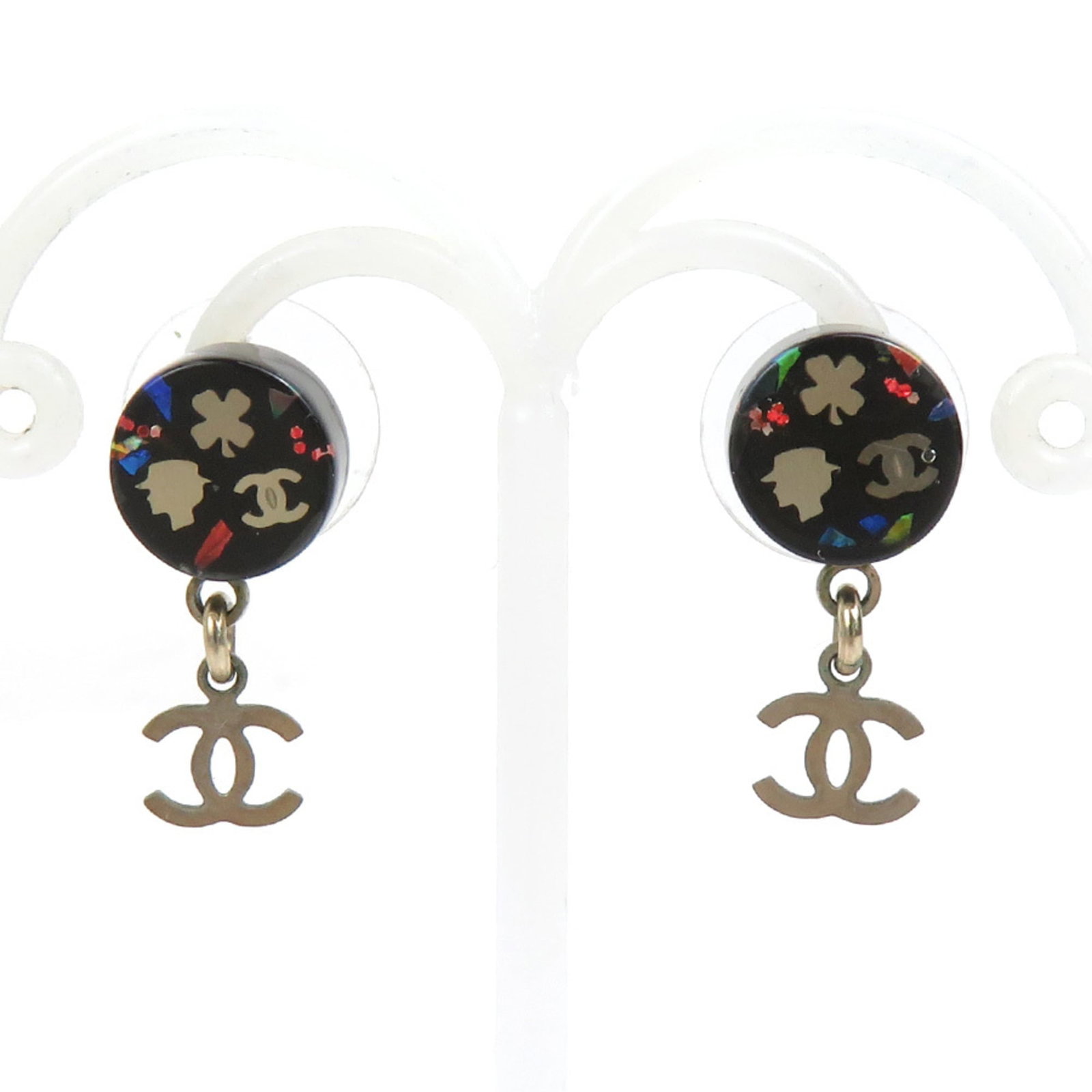 Metal resin stud earrings by Chanel: Metal resin stud earrings by Chanel Metal resin stud earrings by Chanel, featuring a sleek black and silver design. Traces of usage can be seen on these earrings, with minor scratches and dirt