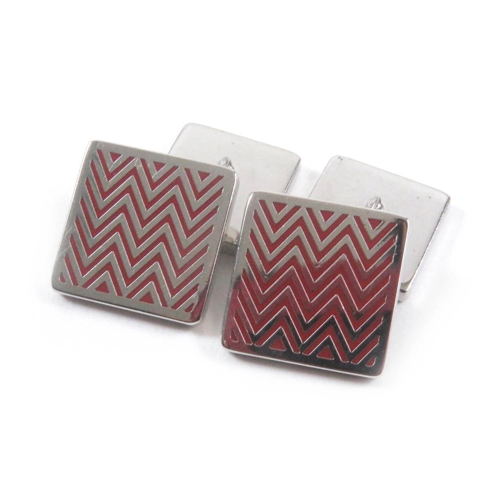 Hermes Cufflinks: Hermes Cufflinks Red and silver Hermes cufflinks in very good condition, with some traces of usage visible. A few scratches and dirt can be seen on the surface, but overall they remain a notable acces