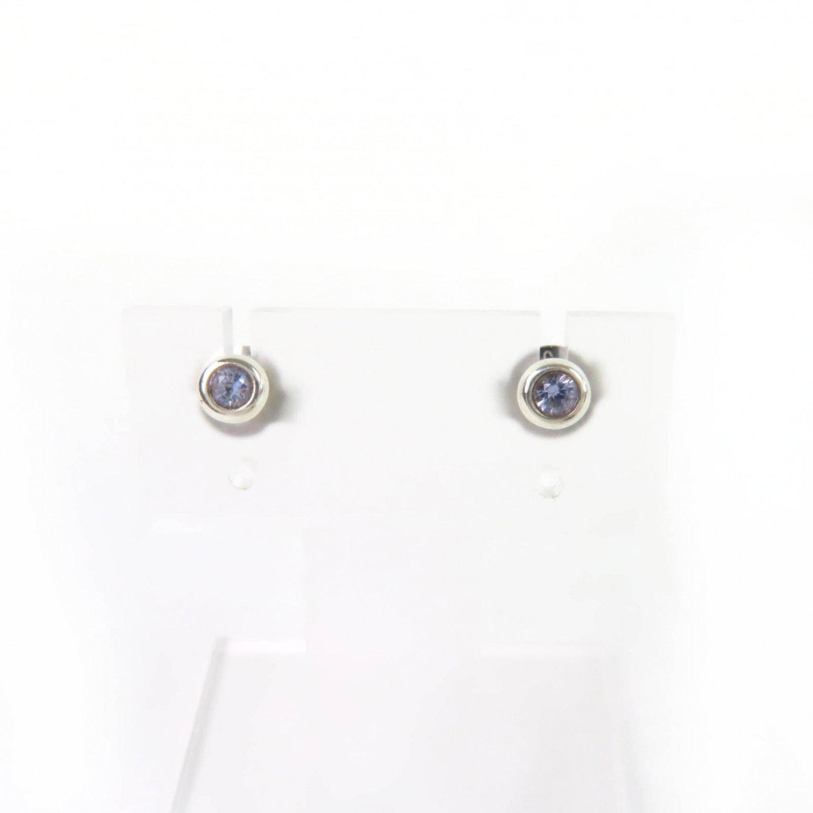 Silver 925 stud earrings by Tiffany: Silver 925 stud earrings by Tiffany Silver 925 stud earrings by Tiffany feature a light blue tanzanite stone, adding a touch of elegance to any outfit. The earrings have been used and show some signs 