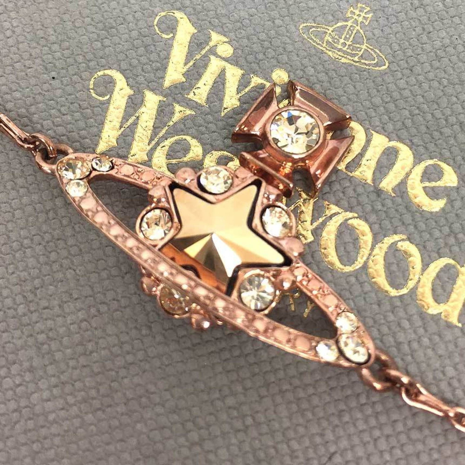 Charm bracelet metal by Westwood Vivienne: Charm bracelet metal by Westwood Vivienne Pink Gold Charm Bracelet by Vivienne Westwood, featuring a unique metal design with subtle scratches and signs of wear, adding to its character. Measuring