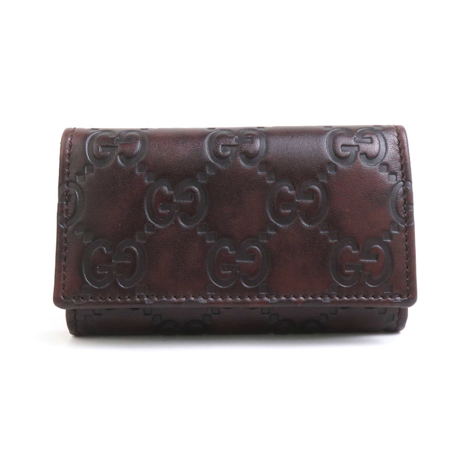 Leather Keycase Gucci: Leather Keycase Gucci Brown leather Gucci keycase with six key hooks, bearing some minor scratches and dirt. Made from genuine leather, this used item has a few traces of usage but remains in very goo