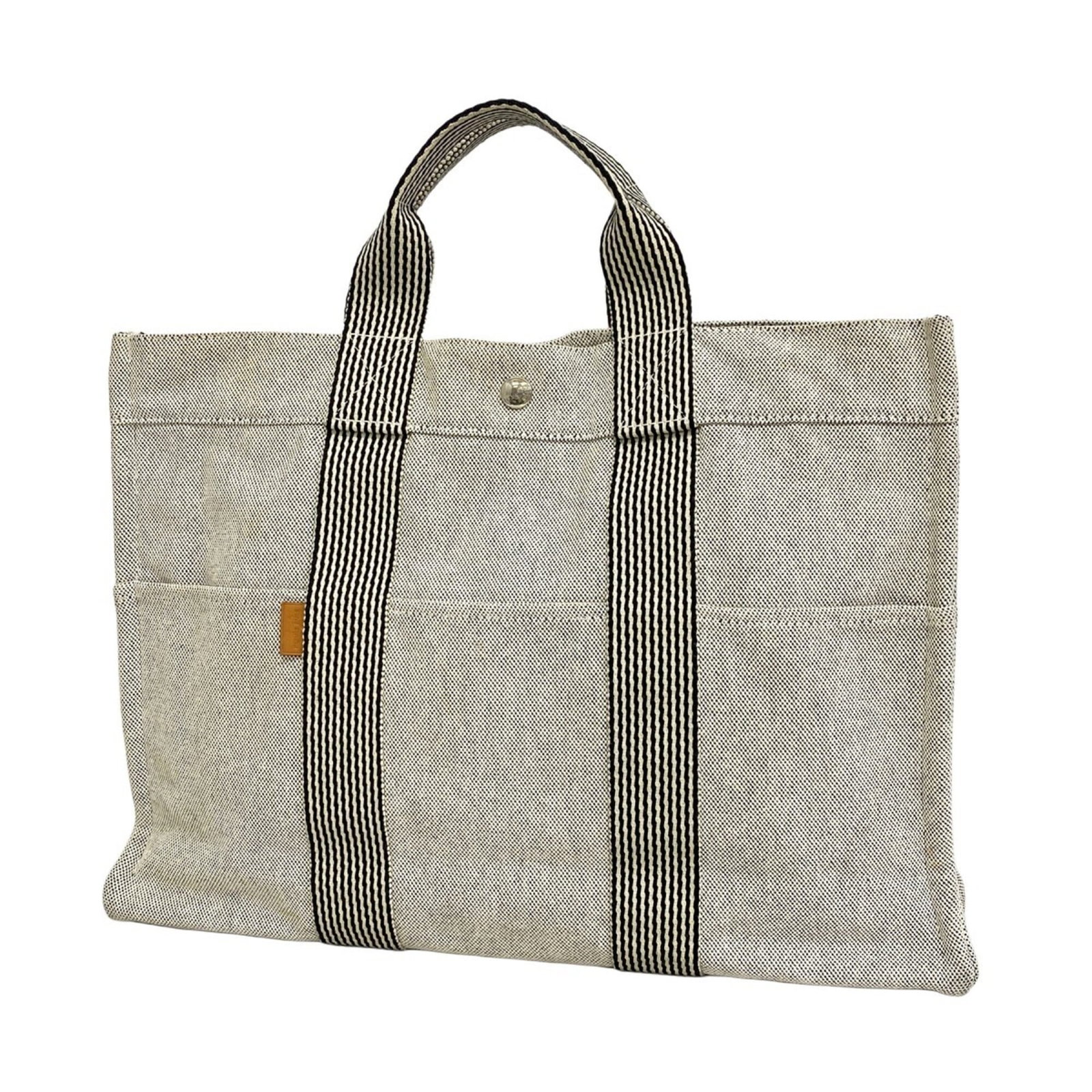 Canvas tote bag by Hermes: Canvas tote bag by Hermes Canvas tote bag by Hermes, featuring a timeless gray canvas material and sleek silver hardware. This pre-owned tote measures 30cm x 42cm x 10cm and showcases subtle signs of
