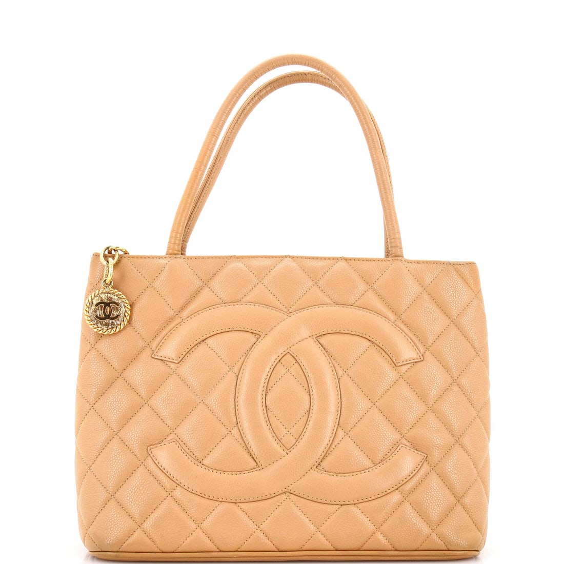 Chanel caviar quilted tote medallion: Chanel caviar quilted tote medallion Touched up base edge and opening edge, this Chanel caviar quilted tote medallion boasts a neutral exterior with scuffs, creases, and edge wear. The quilted design