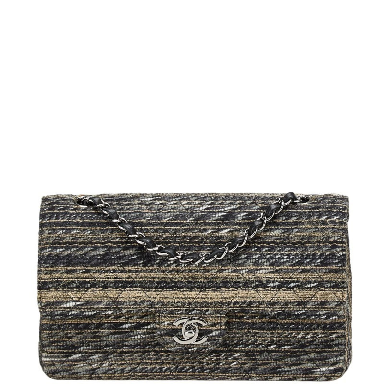 Shoulder bag in tweed by Chanel: Shoulder bag in tweed by Chanel Tweed shoulder bag by Chanel, featuring a classic flap closure and multi-color design. This pre-owned black tweed handbag has a worn-in look with traces of usage,