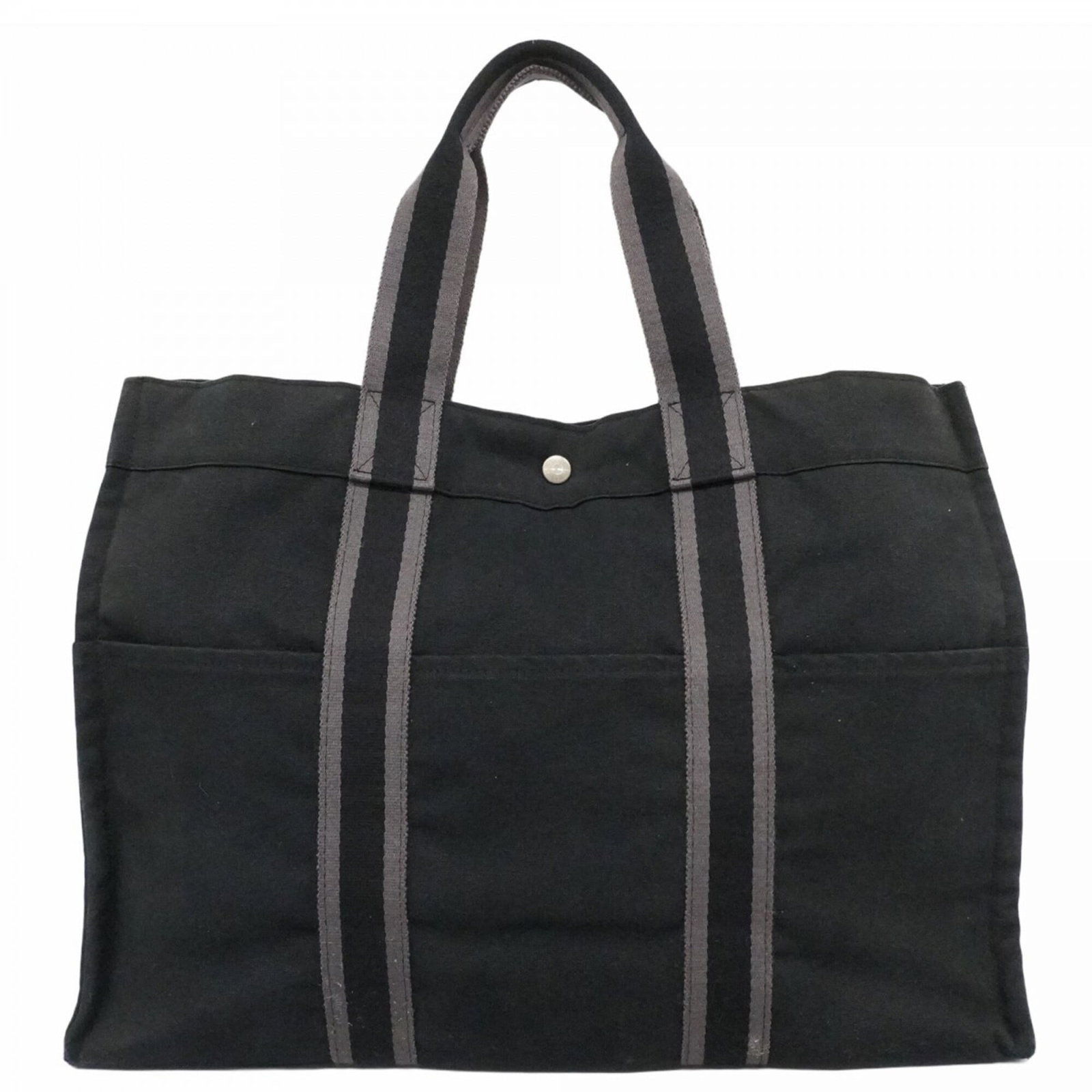 Canvas tote bag by Hermes: Canvas tote bag by Hermes Canvas tote bag by Hermes, featuring black canvas material and silver hardware. This used tote bag has traces of usage with scratches and dirt visible but remains in good