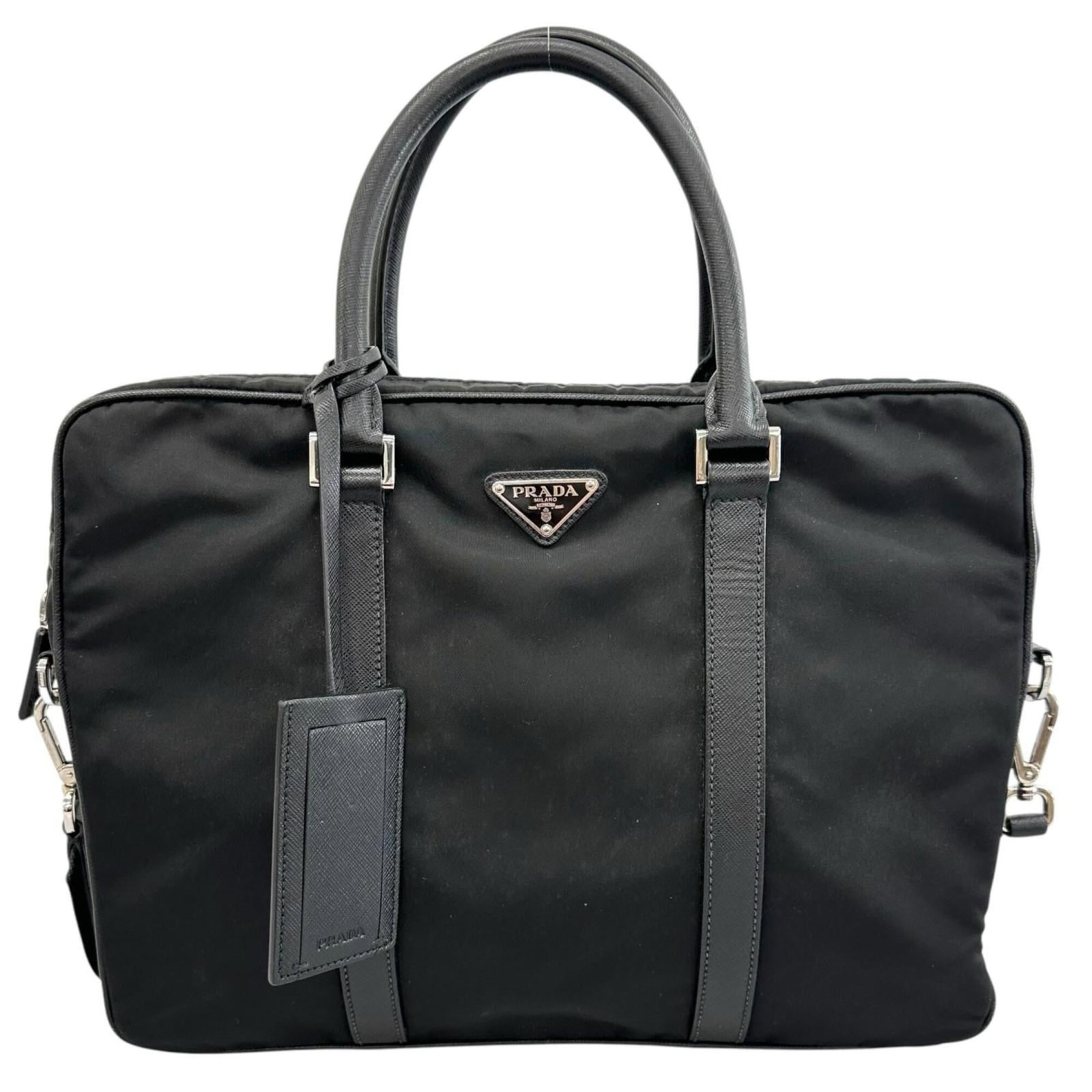 Briefcase nylon handbag by Prada: Briefcase nylon handbag by Prada Black Prada briefcase handbag made from durable nylon, featuring silver hardware. Measuring 27cm x 35cm x 4cm, it has a few traces of usage and some scratches/dirt,