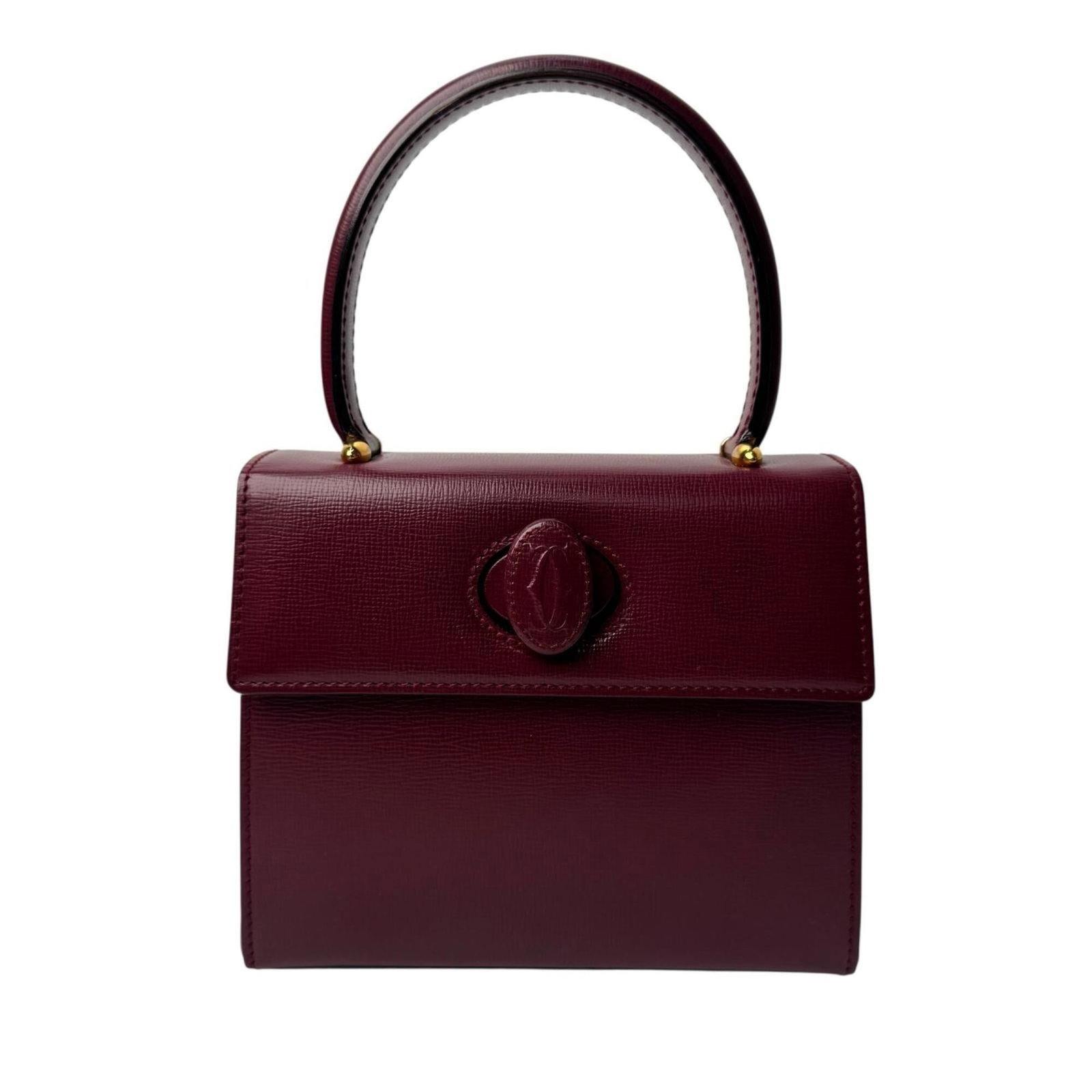 Handbag Leather by Cartier: Handbag Leather by Cartier Cartier handbag in Bordeaux leather, featuring a classic design with subtle scratches and minor dirt marks. The bag measures 15cm x 18cm x 6cm and is in very good condition