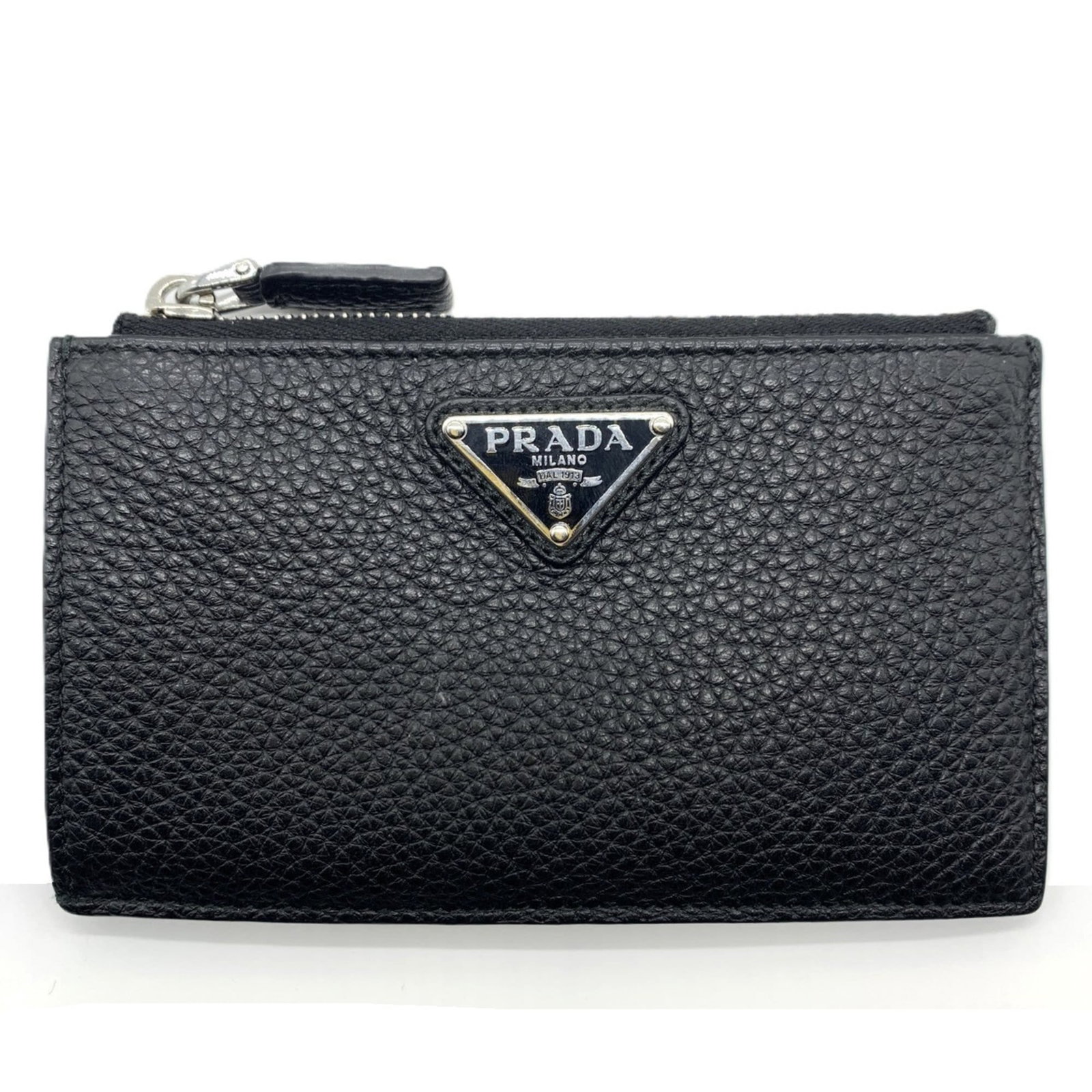 Prada Coin Purse/ Coin Case Vitello Daino: Prada Coin Purse/ Coin Case Vitello Daino The Prada Coin Purse/ Coin Case Vitello Daino features a sleek black design with a snap fastener closure, showcasing the iconic brand's signature style. Made