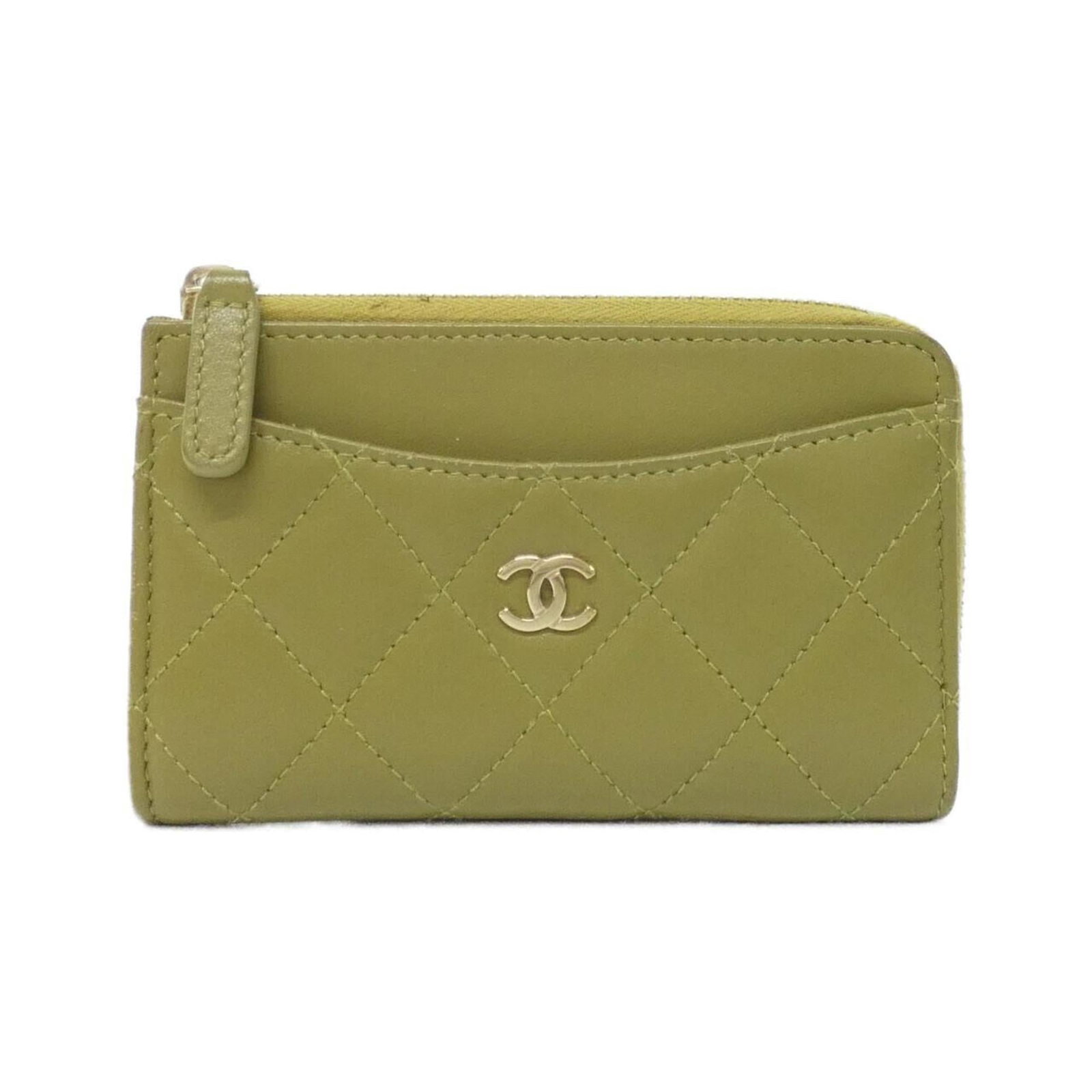 Card case in leather from Chanel: Card case in leather from Chanel The khaki leather card case from Chanel features a classic design with subtle scratches and dirt, giving it a worn-in look. Made from high-quality lamb leather, the