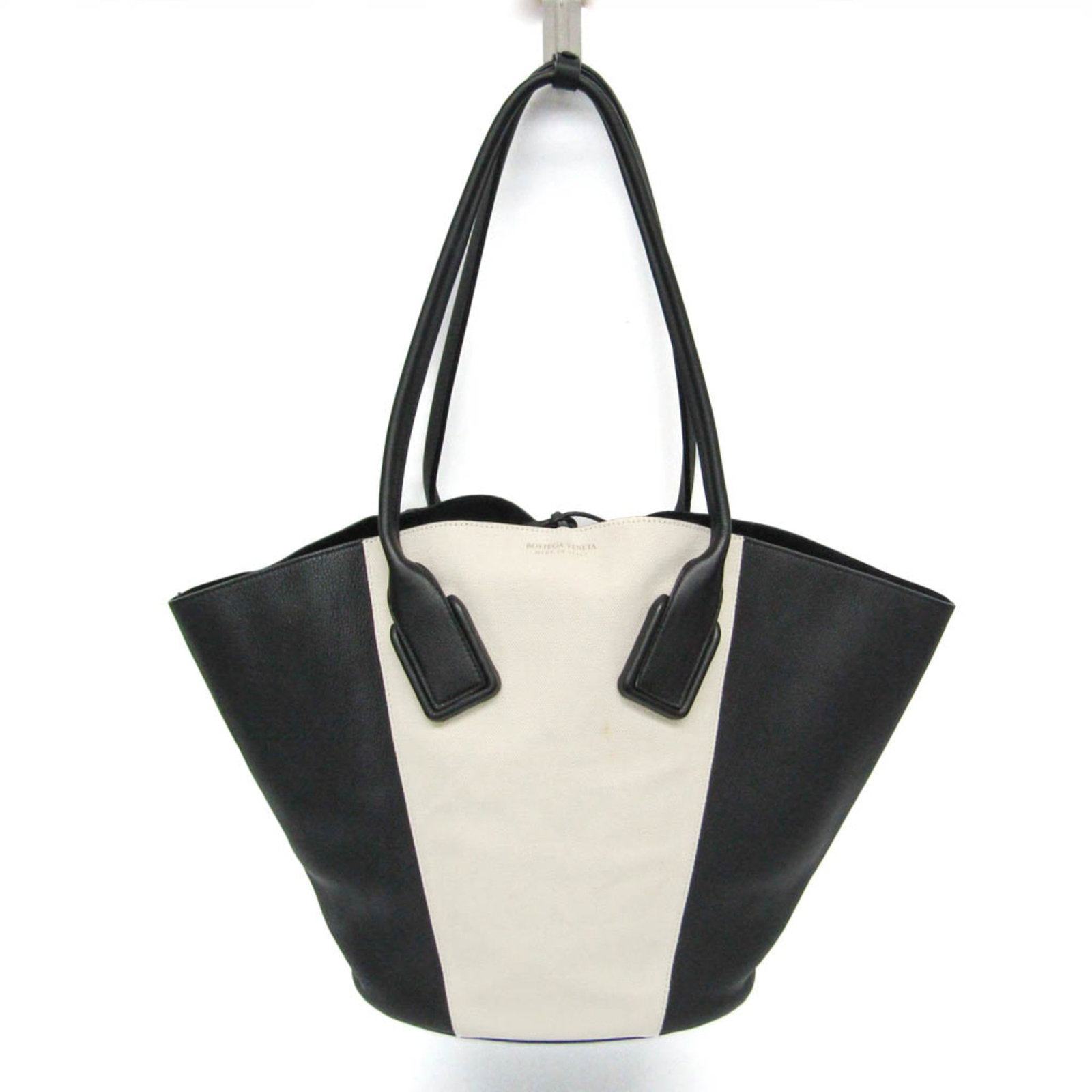 Leather Canvas Tote Bag By Bottega: Leather Canvas Tote Bag By Bottega Bottega Veneta's Leather Canvas Tote Bag boasts a sleek black and off-white design, with a classic string closure. Measuring 33.5cm x 29cm x 21cm, the bag features