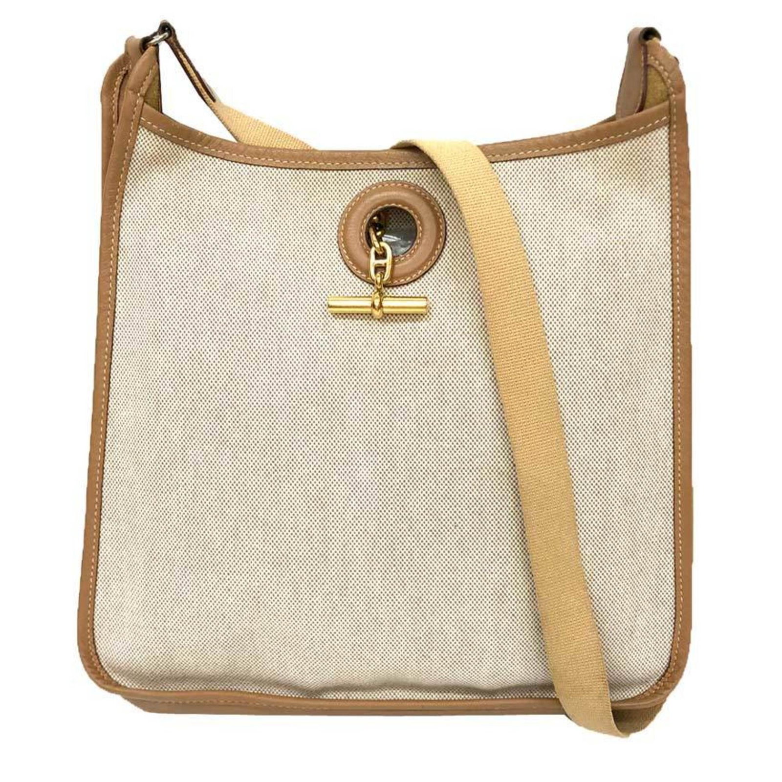 Canvas leather shoulder bag by Hermes: Canvas leather shoulder bag by Hermes Canvas leather shoulder bag by Hermes, featuring a classic design with canvas and leather construction. The camel-colored exterior bears some scratches and dirt, 