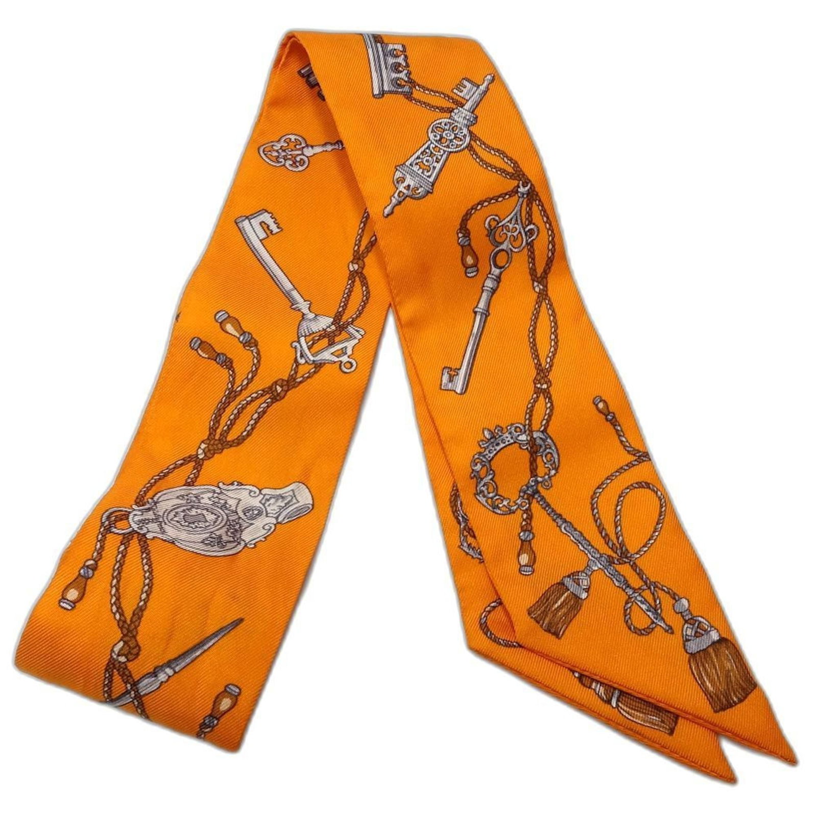 Silk scarf from Hermes: Silk scarf from Hermes Silk scarf from the renowned French fashion house Hermes, boasting a vibrant orange hue. The scarf bears signs of usage, with minor scratches and dirt visible, but remains in