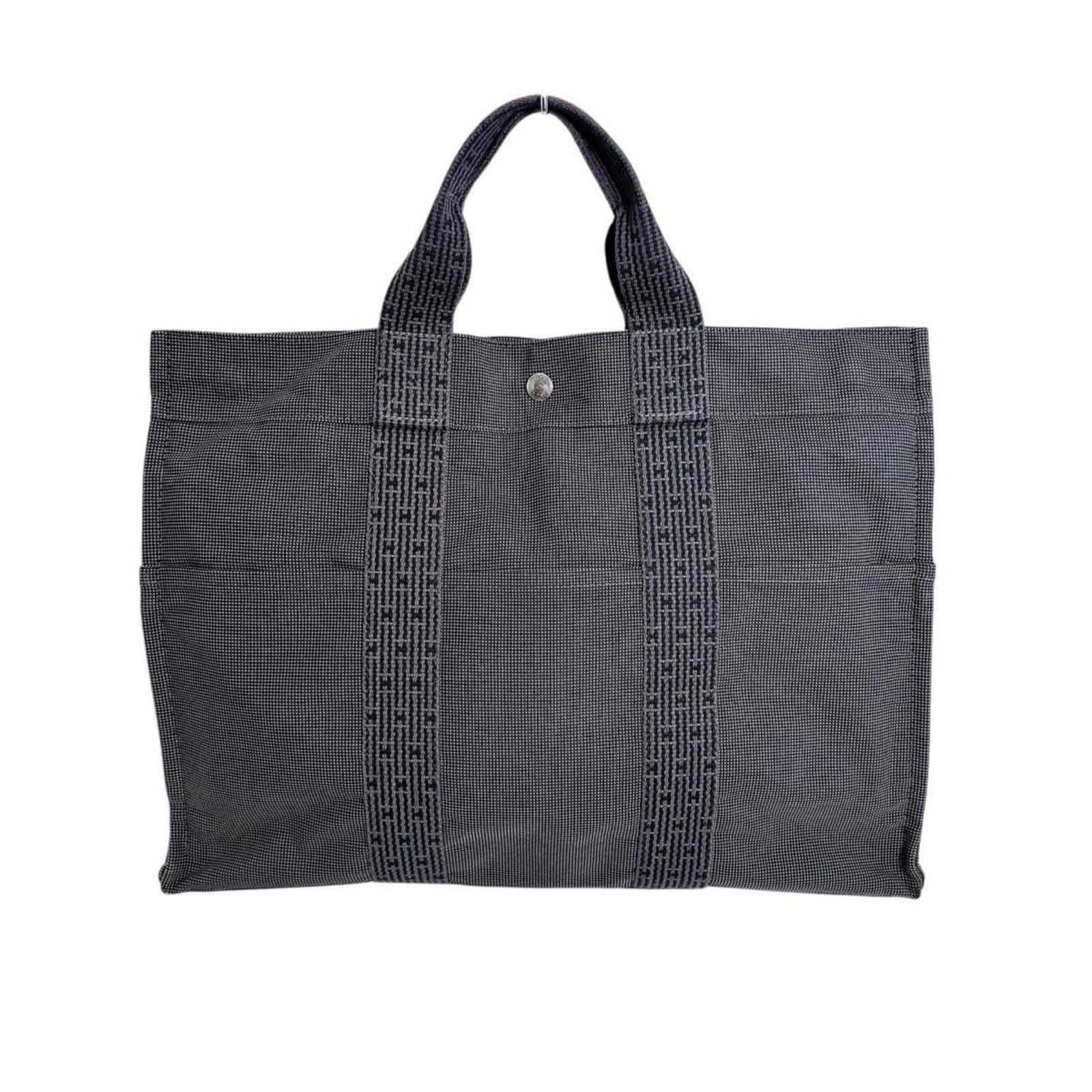 Cotton Hermes Tote Handbag: Cotton Hermes Tote Handbag Gray cotton tote bag from Hermes, featuring a classic design with a 33cm x 42cm x 12cm size and a 10cm handle drop. The bag shows signs of usage, including scratches and dir