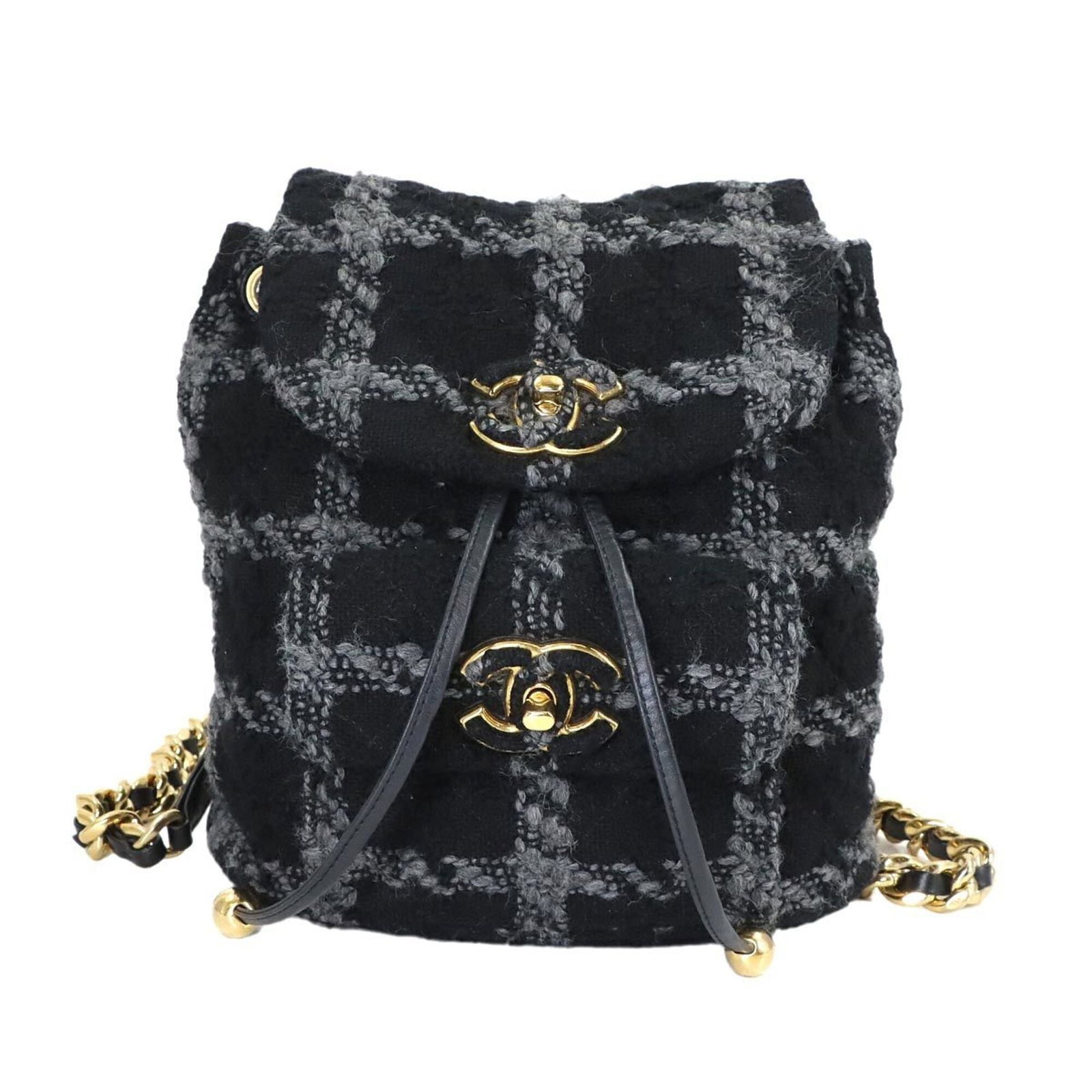 Tweed leather backpack by Chanel: Tweed leather backpack by Chanel Tweed leather backpack by Chanel in black and gray, featuring a classic design with subtle texture from the tweed material. The backpack has some minor scratches and