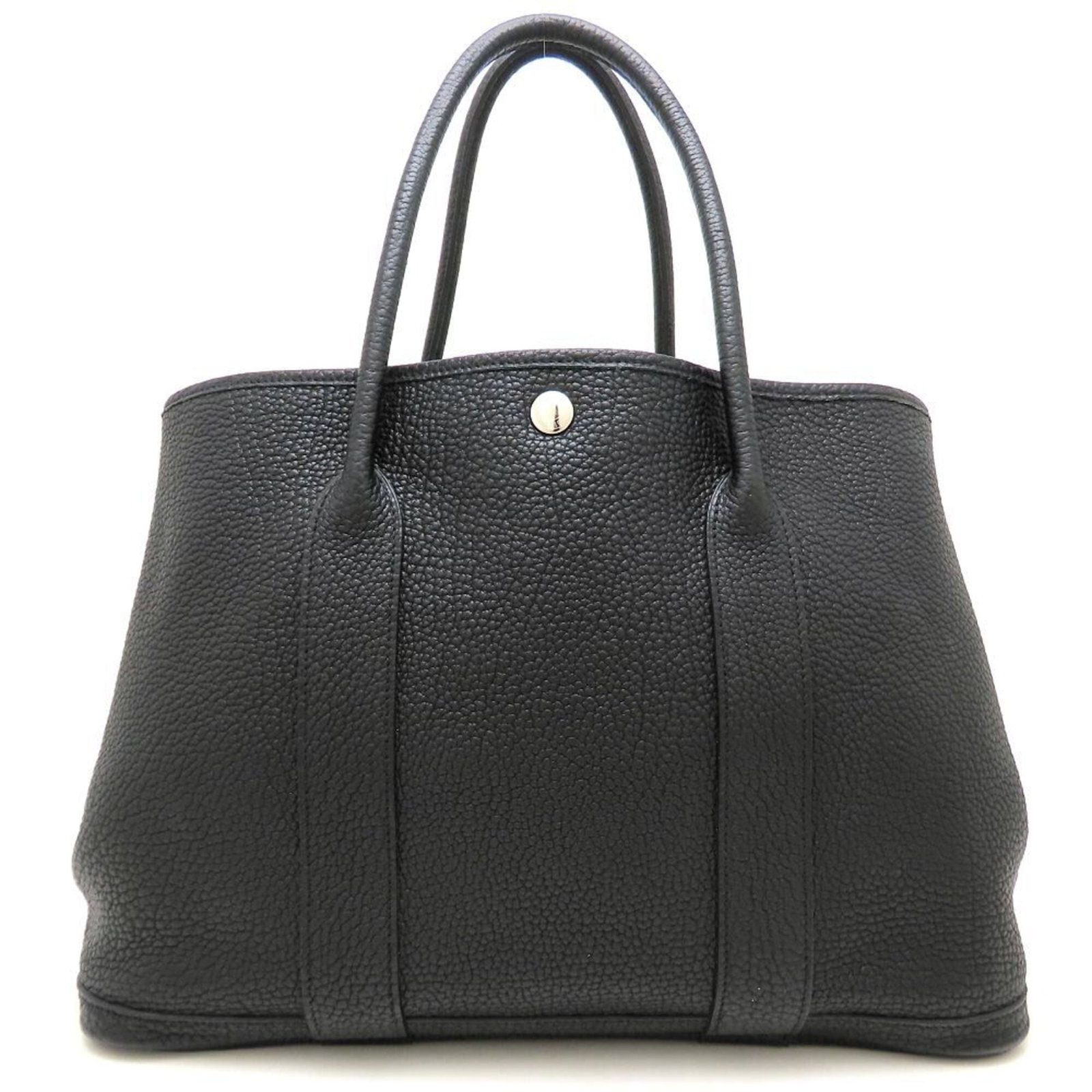 Negonda leather tote by Hermes: Negonda leather tote by Hermes Negonda leather tote by Hermes, featuring black negonda leather and silver hardware. This used tote bag has visible traces of usage with scratches and dirt, but remains