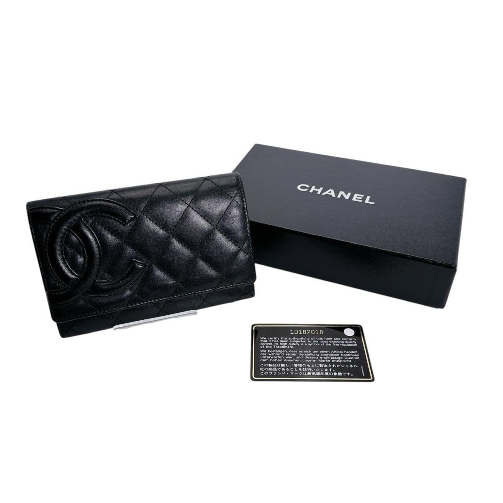 Leather Bi Fold Wallet By Chanel: Leather Bi Fold Wallet By Chanel Black leather bi-fold wallet by Chanel, featuring classic design and timeless style. Traces of usage are visible on the exterior, with minor scratches and dirt