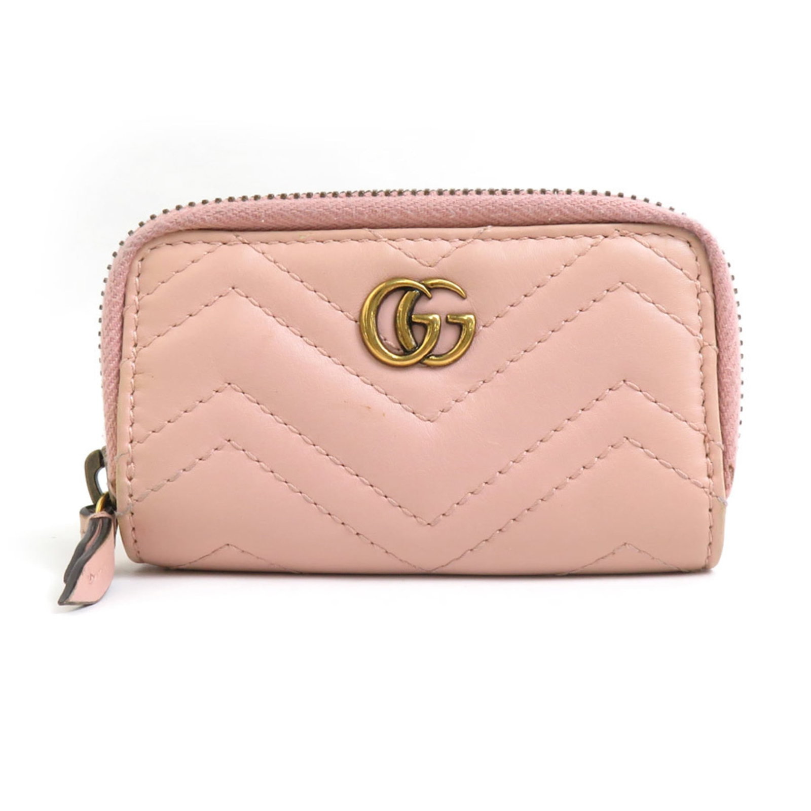 Metal leather keycase Gucci: Metal leather keycase Gucci Gold and pink beige Gucci metal leather keycase, bearing traces of usage with minor scratches and dirt visible. The keycase's metallic accents complement its supple