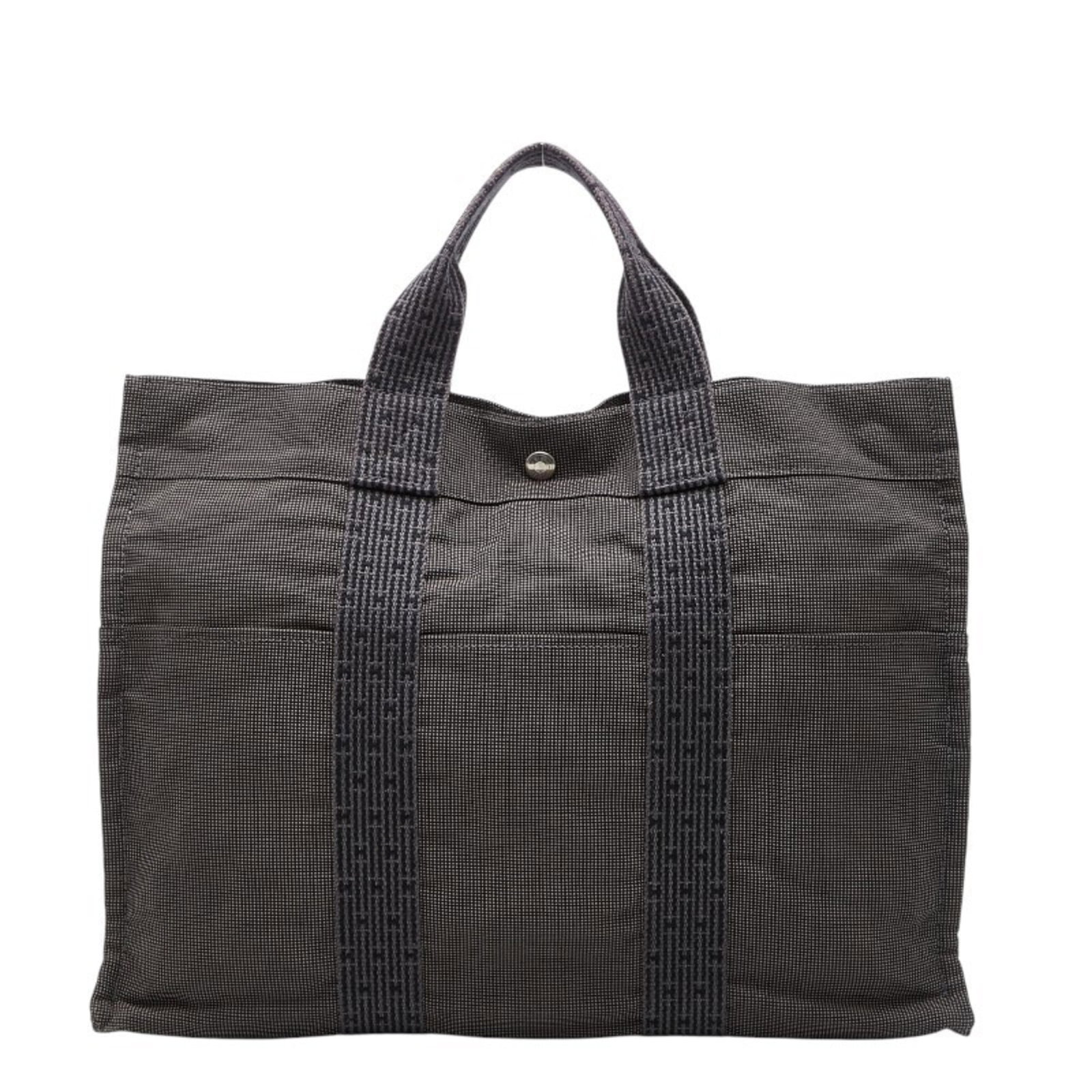 Canvas tote bag handbag Hermes: Canvas tote bag handbag Hermes Canvas tote bag handbag from Hermes, featuring canvas material and a gray color. This used item has traces of usage with visible scratches and dirt, but remains in good