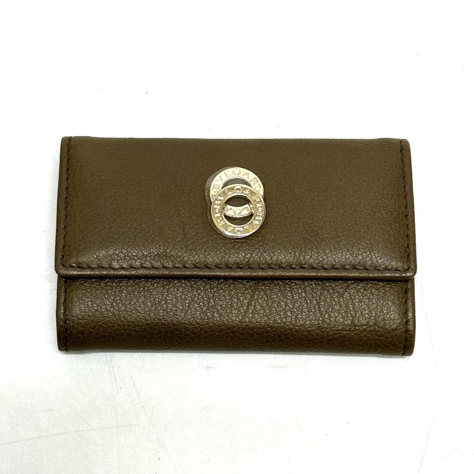 Bvlgari Keycase Leather: Bvlgari Keycase Leather Brown Bvlgari Keycase Leather. Made from high-quality leather, this keycase boasts a classic design that exudes timeless elegance. In mint condition with minimal signs of