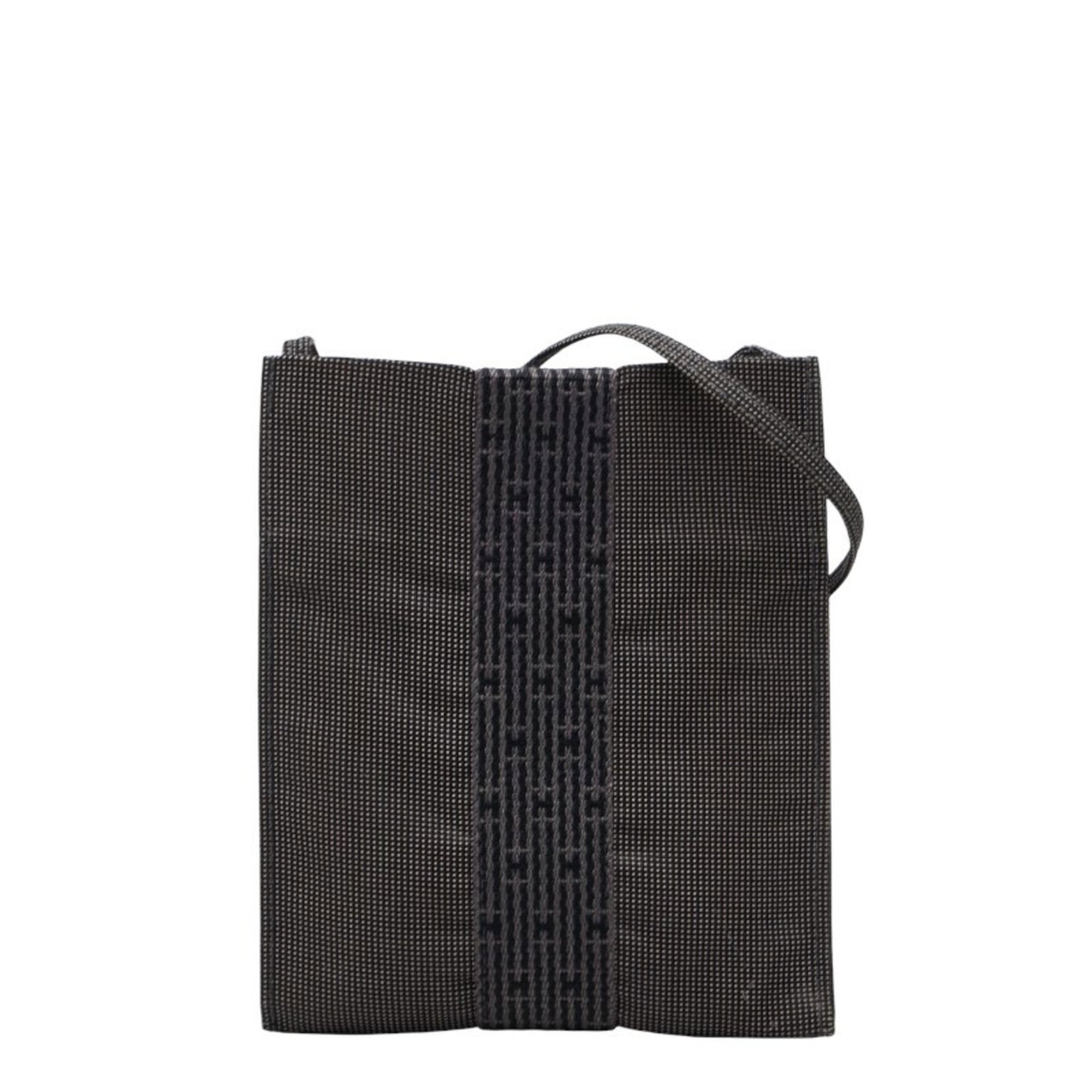 Shoulder bag canvas by Hermes: Shoulder bag canvas by Hermes Canvas by Hermes, a versatile and chic shoulder bag in black and gray tones. This pochette features an open closure and adjustable strap drop for a comfortable fit. With