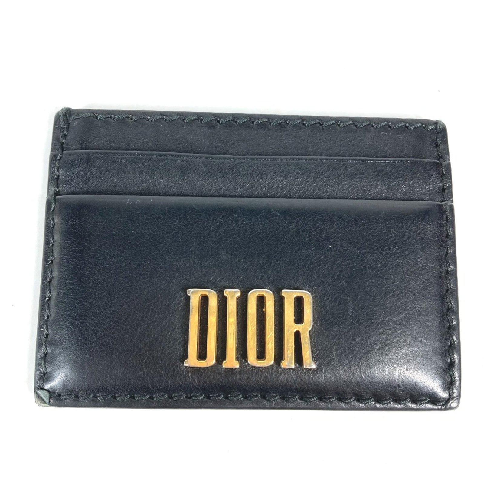 Christian Dior Card Case Leather: Christian Dior Card Case Leather Used Christian Dior Card Case Leather in black, with traces of usage and minor scratches. The card case measures 10cm x 7cm (3.9" x 2.8") and is made from genuine leat
