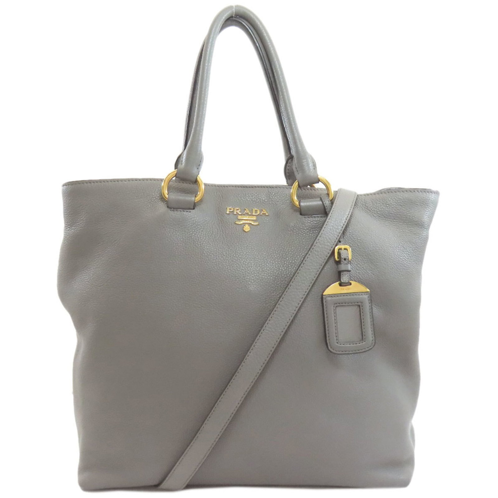 Tote Bag Leather by Prada: Tote Bag Leather by Prada This Prada tote bag features high-quality leather made from calfskin, with a distinctive gray color. The bag has undergone normal wear and tear, showing traces of usage and m