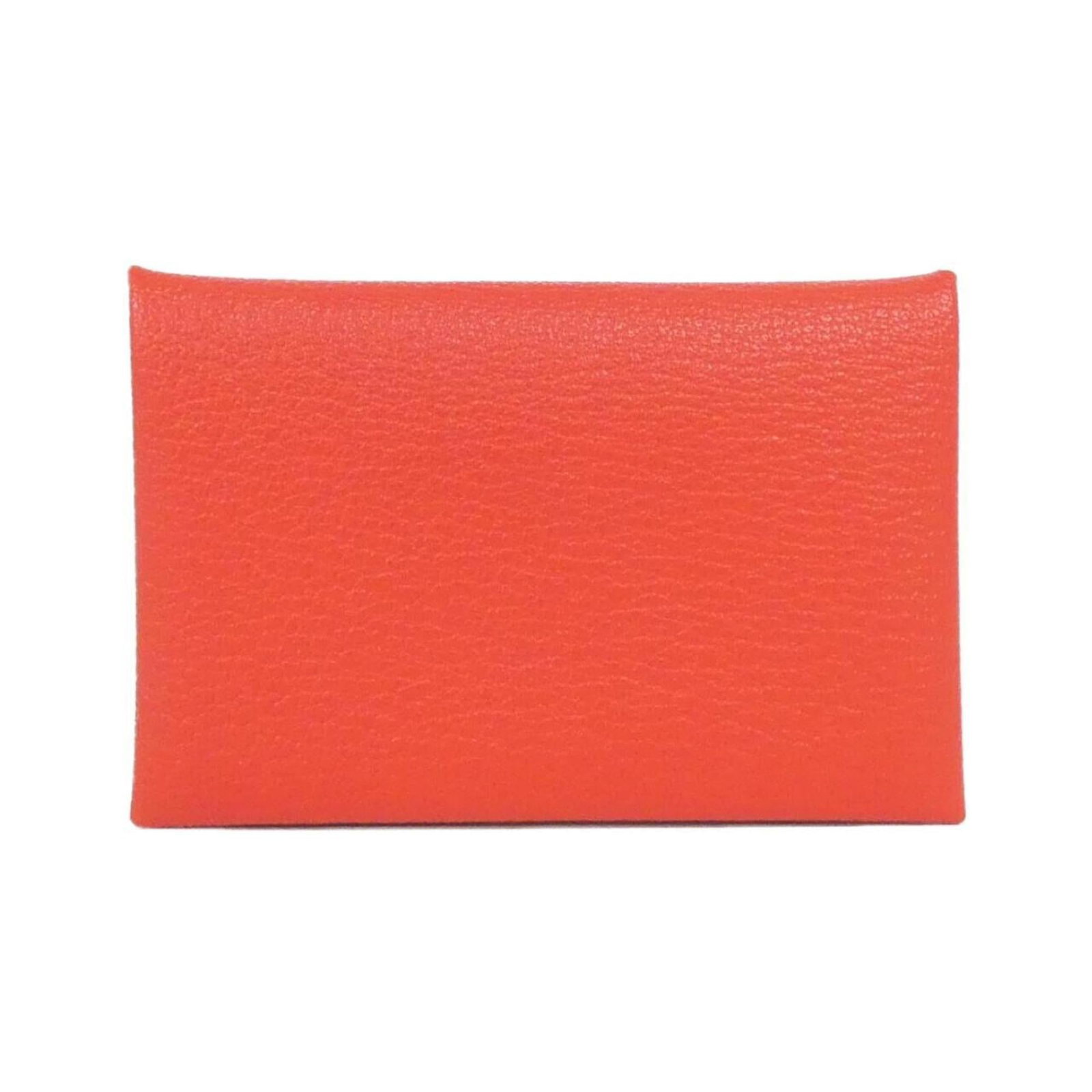 Chevre leather card case by Hermes: Chevre leather card case by Hermes Red chevre leather card case by Hermes, featuring a subtle, natural finish and a few traces of usage visible. The case bears some scratches and dirt but remains in