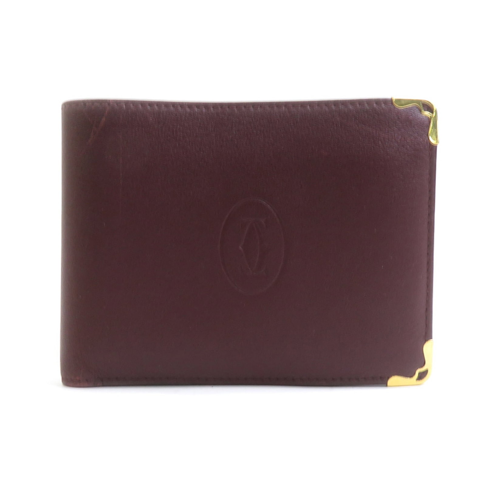 Cartier Wallet (Bi-Fold) Leather: Cartier Wallet (Bi-Fold) Leather Bordeaux leather Cartier bi-fold wallet, with its classic design and timeless elegance. The used condition reveals subtle signs of wear, including scratches and dirt,