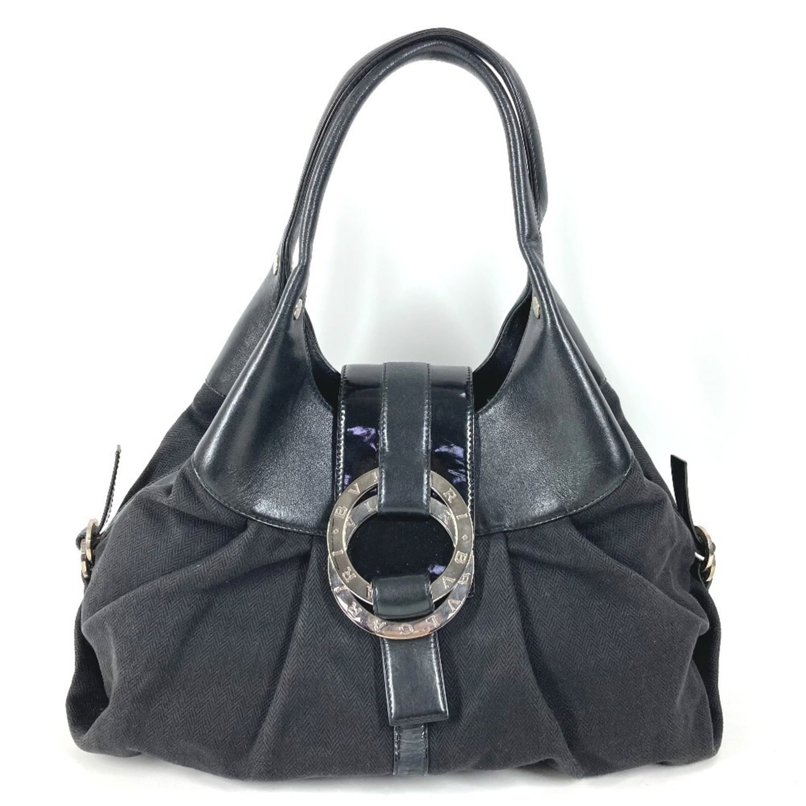 Shoulder Bag Leather Canvas Tote By Bvlgari: Shoulder Bag Leather Canvas Tote By Bvlgari Black leather and canvas tote bag by Bvlgari, featuring silver hardware. The bag measures 25cm x 38cm x 14cm and has a worn, used appearance with scratches 