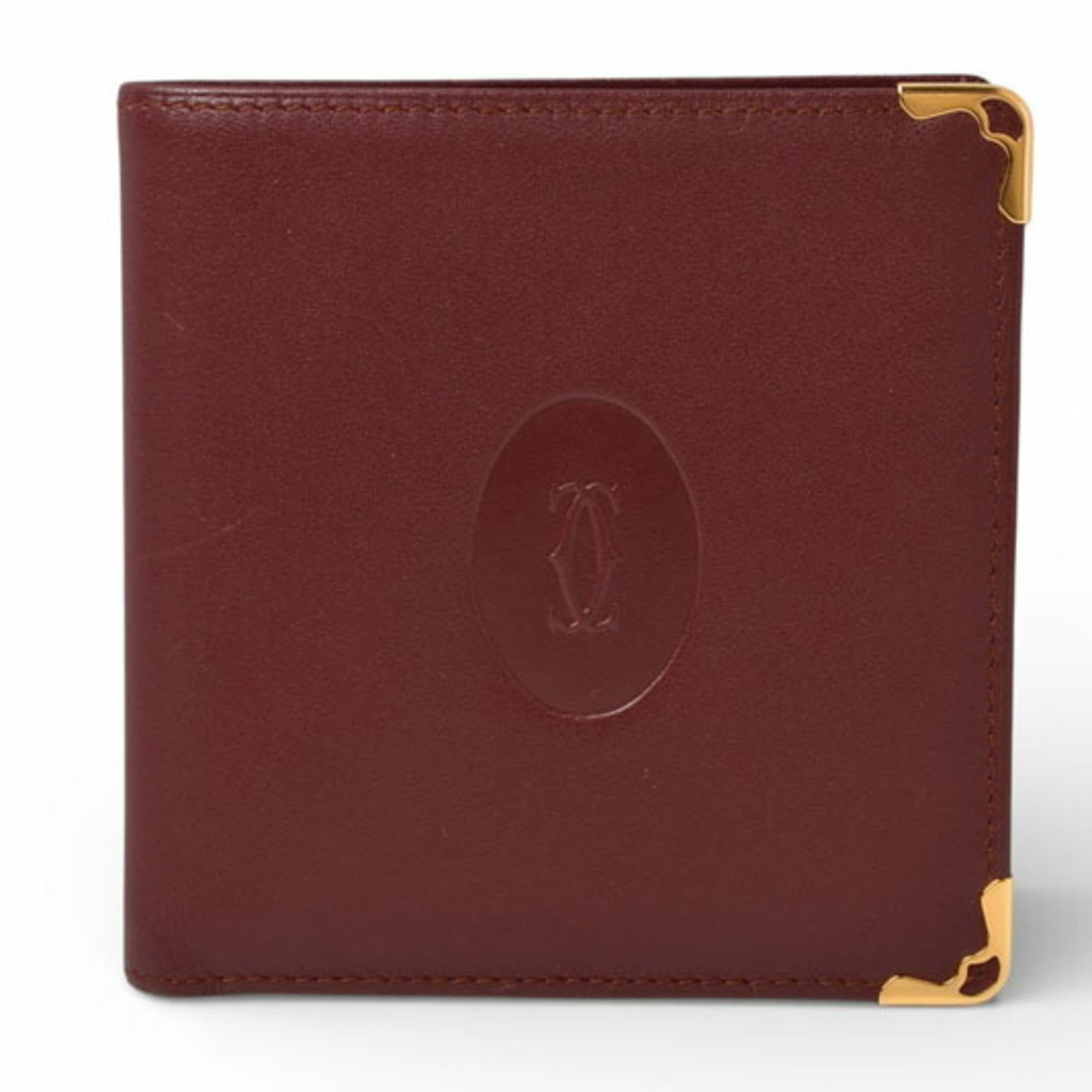 Cartier Wallet (Bi-Fold) Leather: Cartier Wallet (Bi-Fold) Leather Bordeaux leather Cartier bi-fold wallet, featuring an open closure and classic design. Showcasing subtle signs of usage, including scratches and dirt, this pre-owned