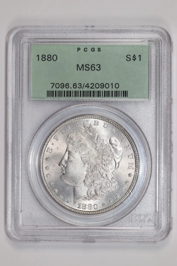 1880 MORGAN DOLLAR PCGS MS63 OGH PQ: 1880 MORGAN DOLLAR PCGS MS63 OGH PQ The 1880 Morgan Dollar, graded MS63 by PCGS, boasts exceptional condition with a high level of detail preserved. Certified Uncirculated and bearing the mark of the
