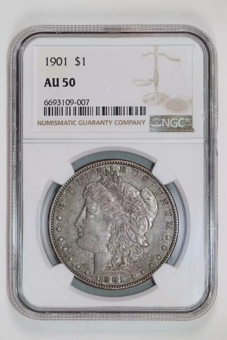 MORGAN DOLLAR 1901 NGC AU50: MORGAN DOLLAR 1901 NGC AU50 The Morgan Dollar 1901 NGC AU50 features a striking silver composition and a circulated state, showcasing the wear and tear of its age. Certified by the Numismatic Guaranty