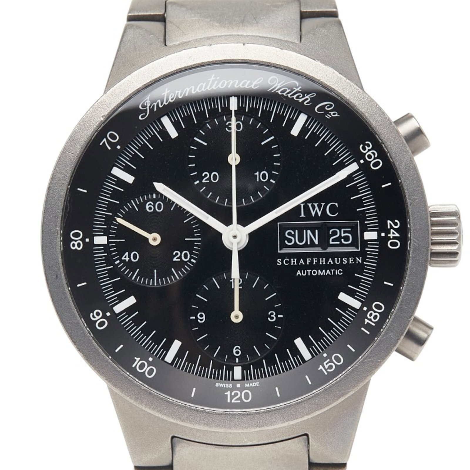 Wristwatch by Iwc: Wristwatch by Iwc Titanium case and band, black dial, and 39.6mm diameter make for a sleek and modern timepiece. The watch bears traces of usage with scratches and dirt visible but remains in good