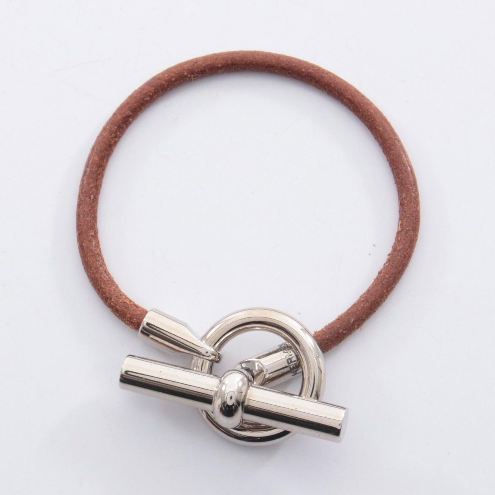 Hermes Stainless Steel Leather Bracelet: Hermes Stainless Steel Leather Bracelet Stainless steel and supple leather come together in this sleek, 17cm charm bracelet from Hermes. The combination of materials adds a touch of sophistication to