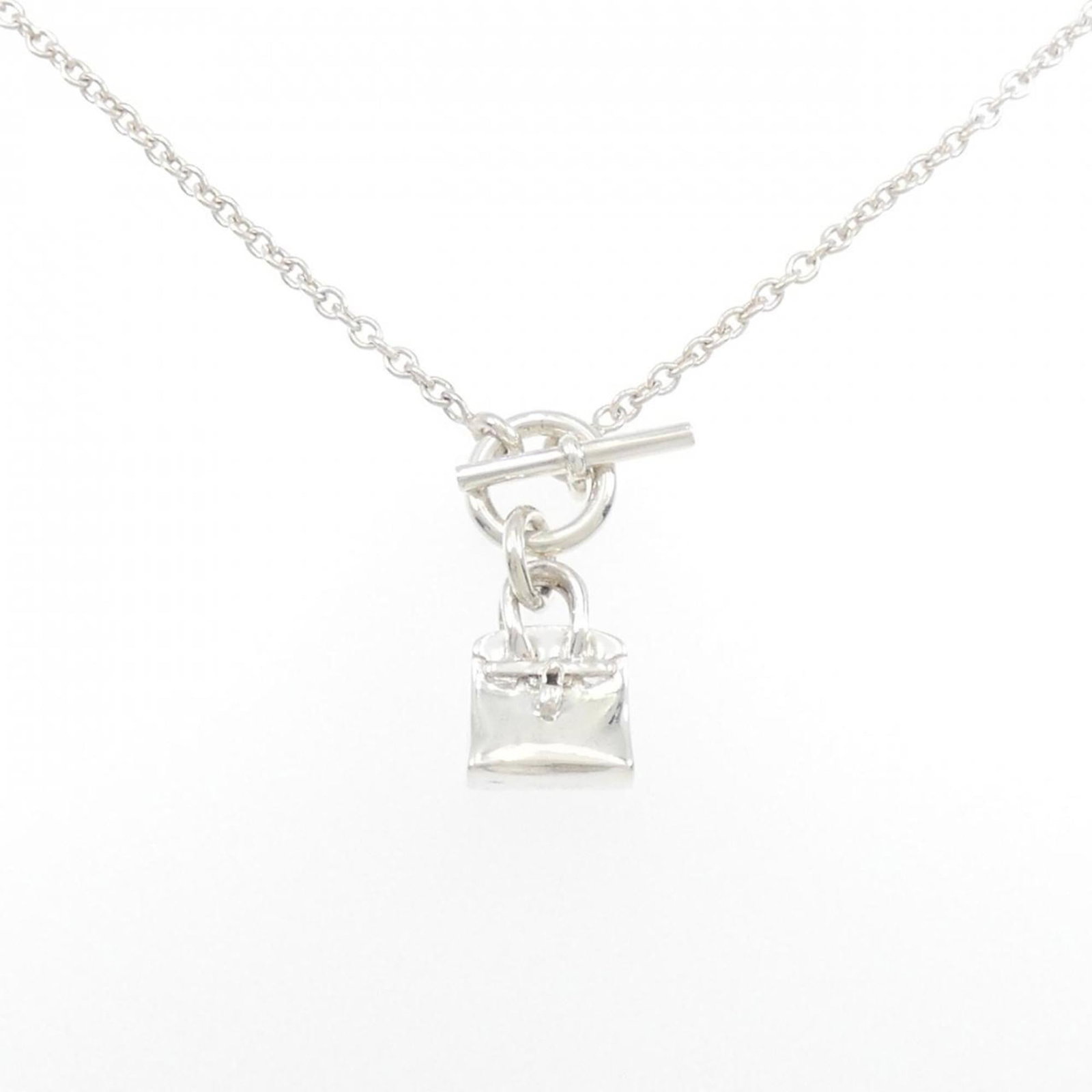 Birkin Hermes Necklace Amulet: Birkin Hermes Necklace Amulet Silver Birkin Hermes Necklace Amulet, featuring a 28.5mm x 11.6mm pendant on a silver chain with a 38 cm circumference, made from high-quality 925 silver material. The