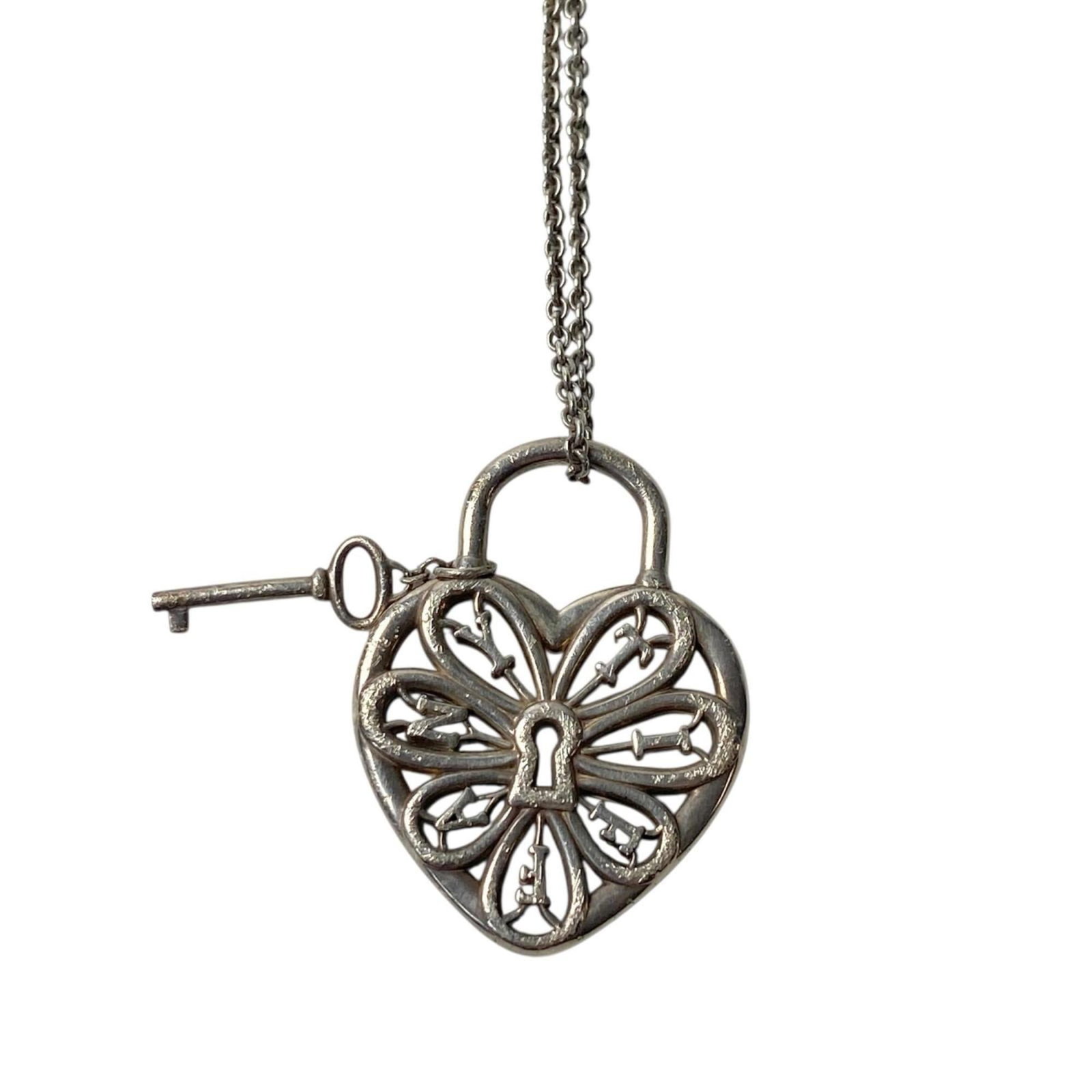 Filigree heart key necklace for women: Filigree heart key necklace for women Silver filigree heart pendant, 23mm x 30mm in size, suspended from a 41cm chain. The intricate filigree design adds visual interest to the classic silver