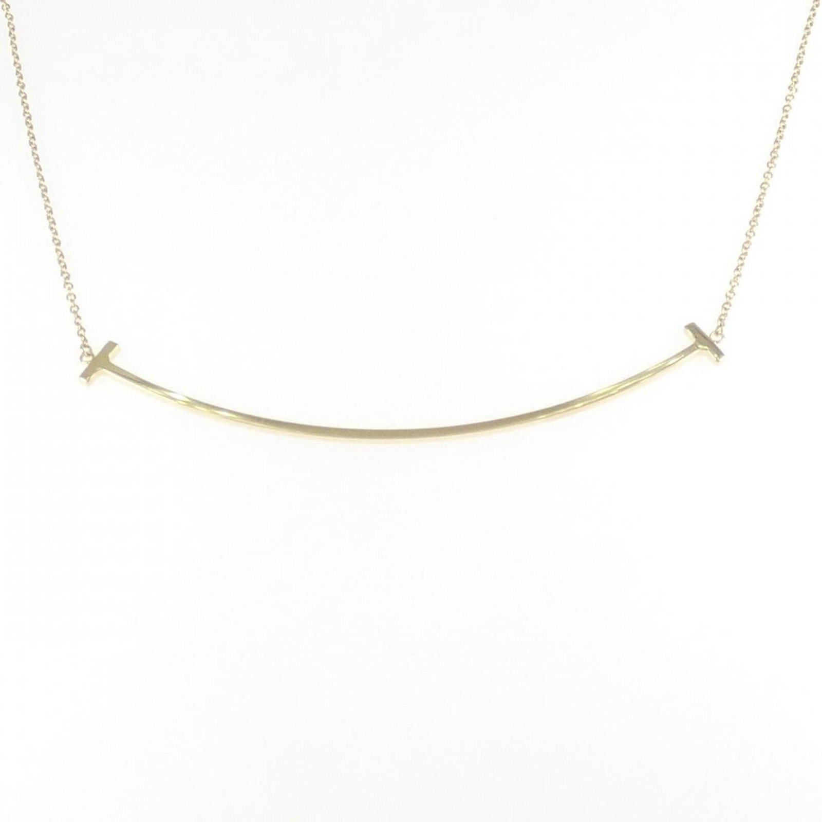 Tiffany & Co. T Smile Large Necklace: Tiffany & Co. T Smile Large Necklace Tiffany & Co.'s T Smile Large Necklace boasts an elegant design, featuring a 5.7mm x 68.7mm pendant in yellow gold, suspended from a chain that accommodates neck