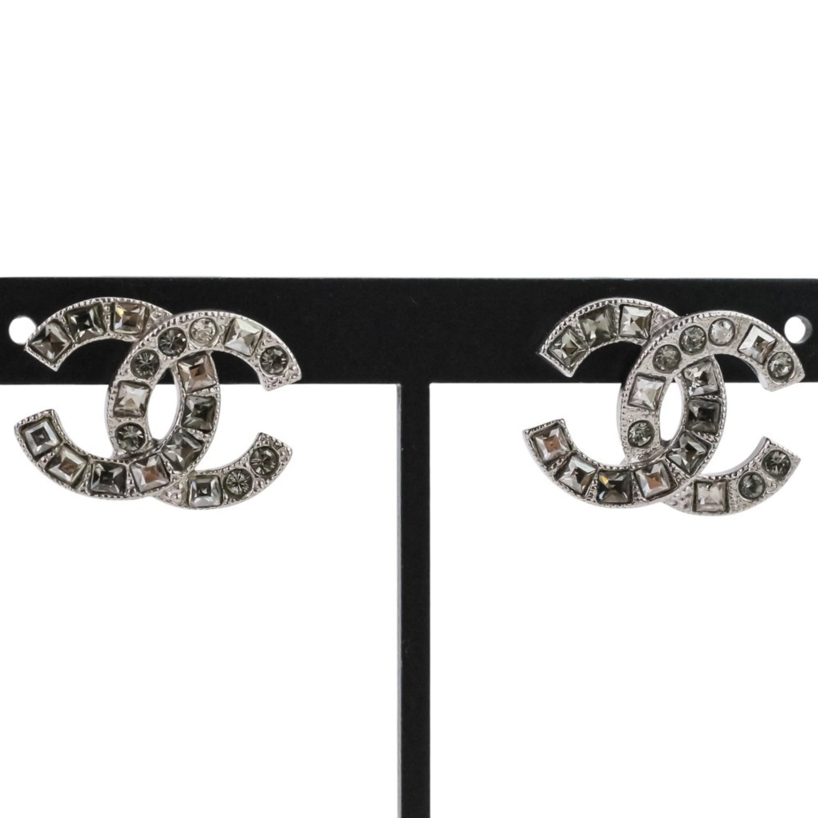 Chanel Stud Earrings: Chanel Stud Earrings Stud earrings from the iconic Chanel brand, featuring a sleek silver design. The compact size and minimalist aesthetic make them a versatile addition to any outfit. Presented in a