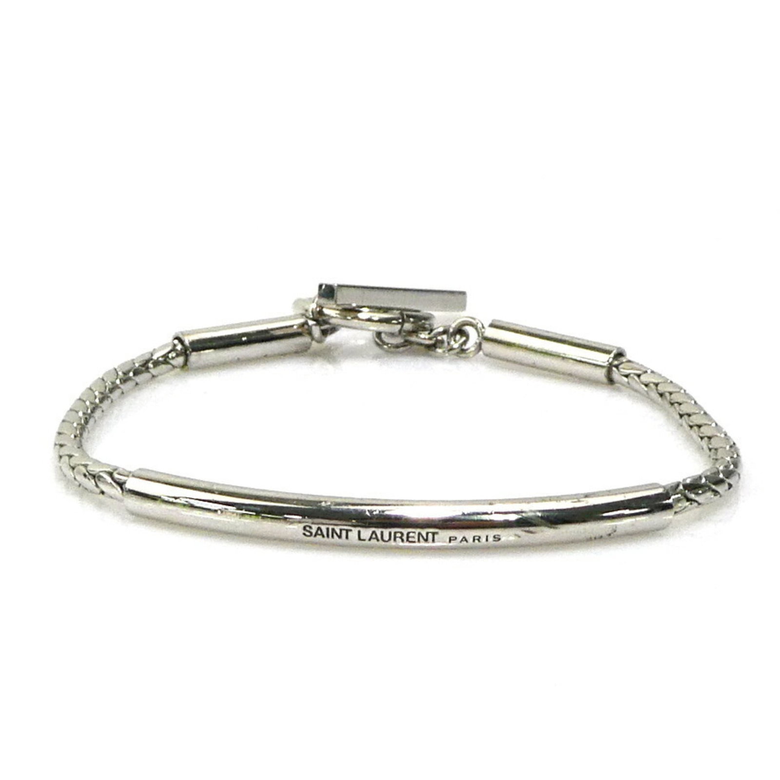 Saint Laurent Metal Charm Bracelet: Saint Laurent Metal Charm Bracelet Silver charm bracelet from Saint Laurent, measuring 17cm in length. This metal charm bracelet features the iconic brand's signature style with its sleek design and
