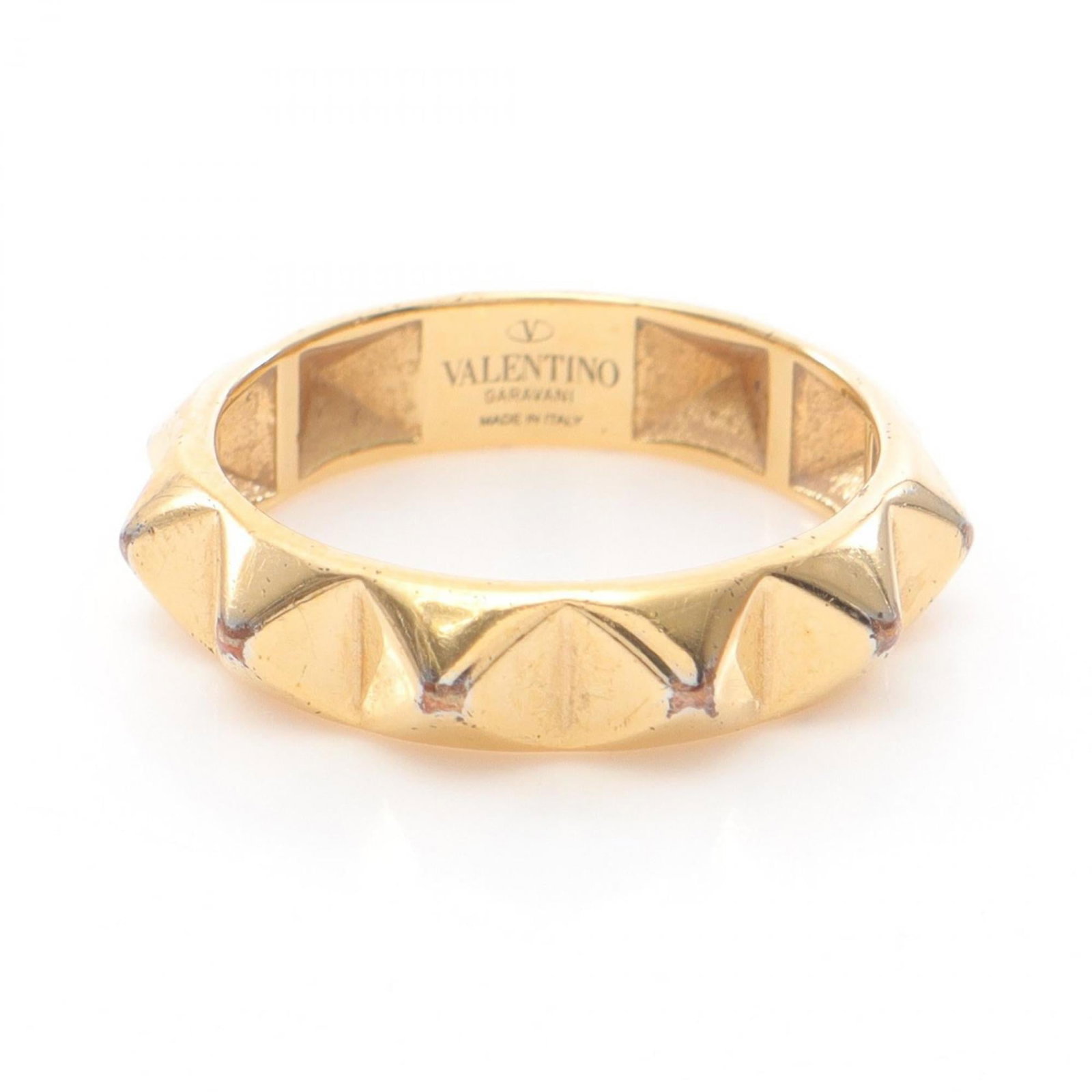 Valentino Band Ring Gold Plating: Valentino Band Ring Gold Plating Valentino's iconic band ring is crafted from gold plating, adding a touch of luxury to any outfit. This elegant design features the brand's signature style and is