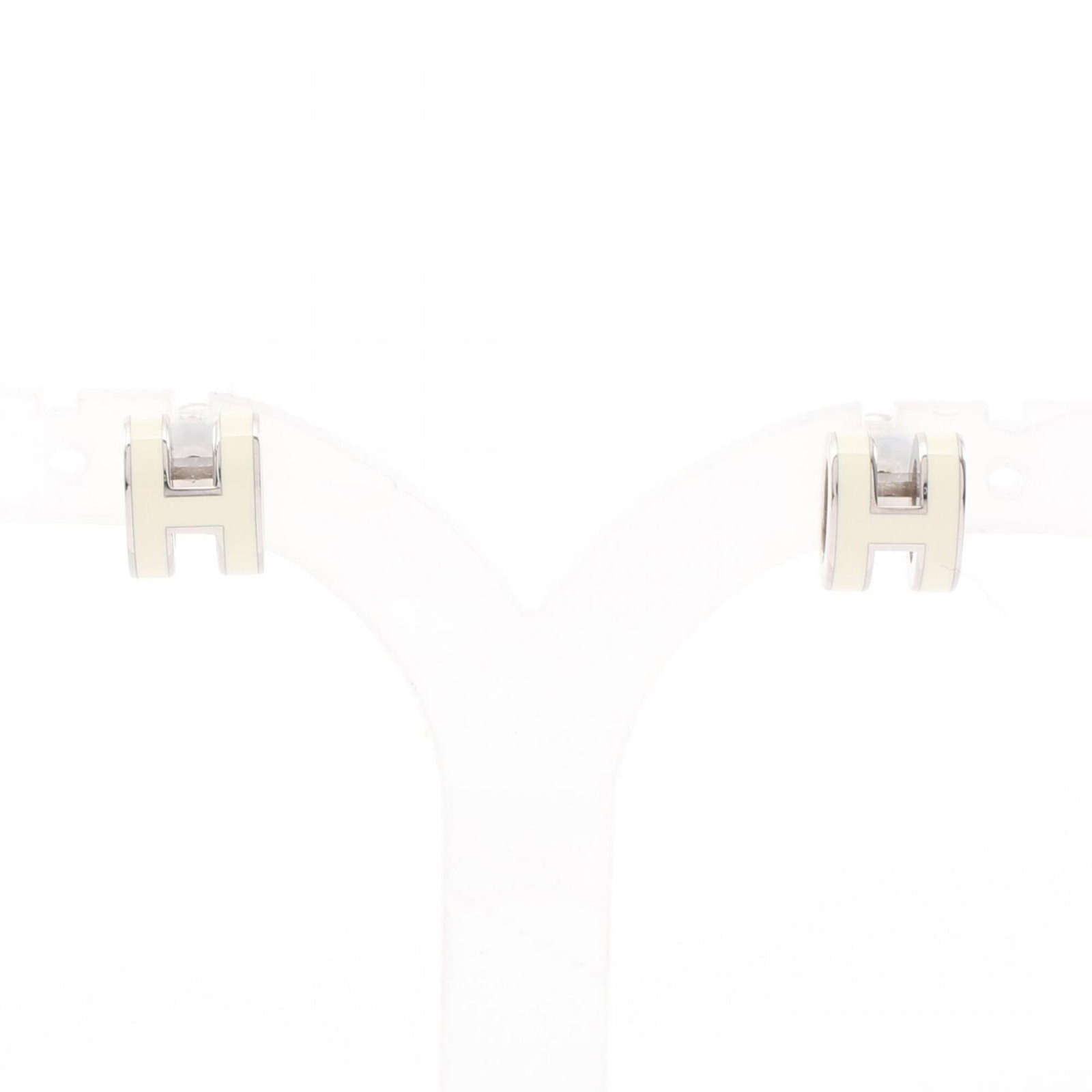 Hermes Steel Earrings Stud: Hermes Steel Earrings Stud Stainless steel stud earrings from the Hermes line, featuring an ivory and silver finish. The earrings measure 9.00mm in height and 7.00mm in width, with a diameter of 0.35'