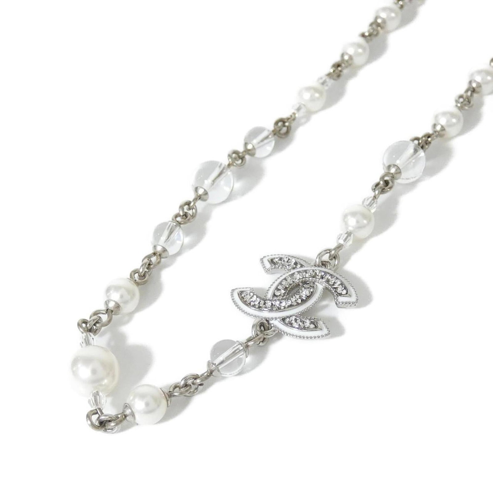 Abe883 Necklace of Chanel: Abe883 Necklace of Chanel The Abe883 Necklace of Chanel boasts a sleek, modern design with a clear crystal pendant suspended from a silver chain. Measuring 15mm x 20mm in size, the pendant is