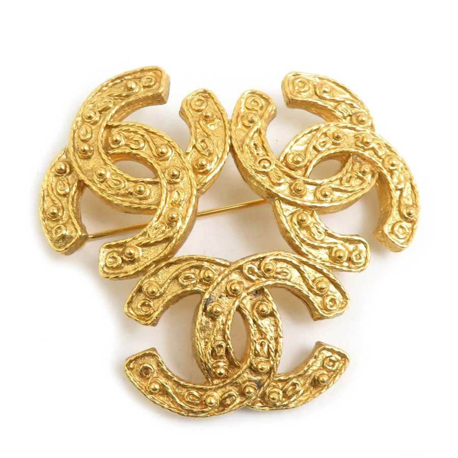 Metal Chanel Brooch: Metal Chanel Brooch This gold metal Chanel brooch from France features a sleek design with precise measurements, measuring 5cm x 5.3cm / 1.96'' x 2.08''. The brooch bears the signature of its