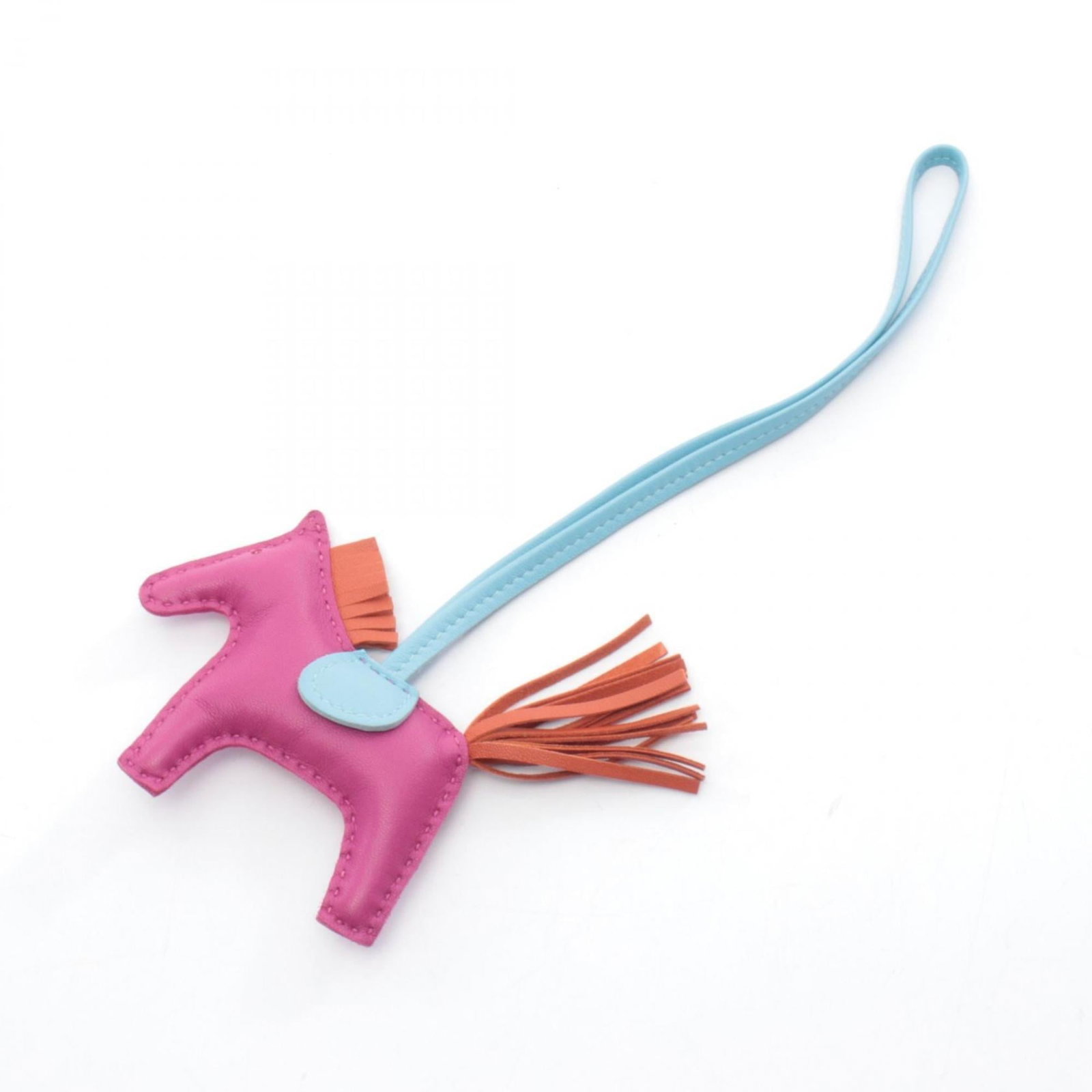 Hermes leather agneau handbag charm: Hermes leather agneau handbag charm Agneau Milo leather charm from Hermes, available in Bordeaux and Pink. This handbag charm showcases the luxury of high-quality agneau leather, a distinctive materia