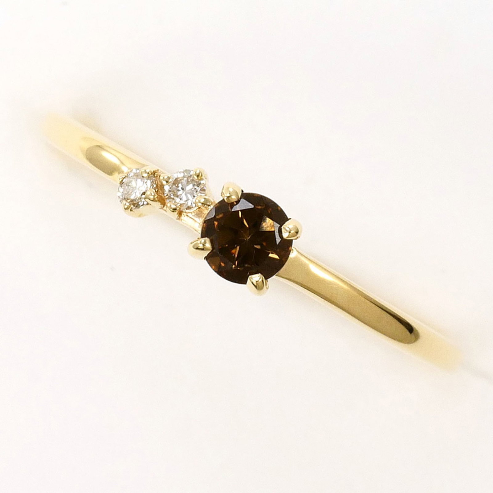 Unbranded band ring yellow gold 10K: Unbranded band ring yellow gold 10K Yellow gold band ring with a diamond and smoky quartz stone, crafted from 10K metal. Measuring 3mm in width and weighing 0.6g, this unbranded piece offers a subtle