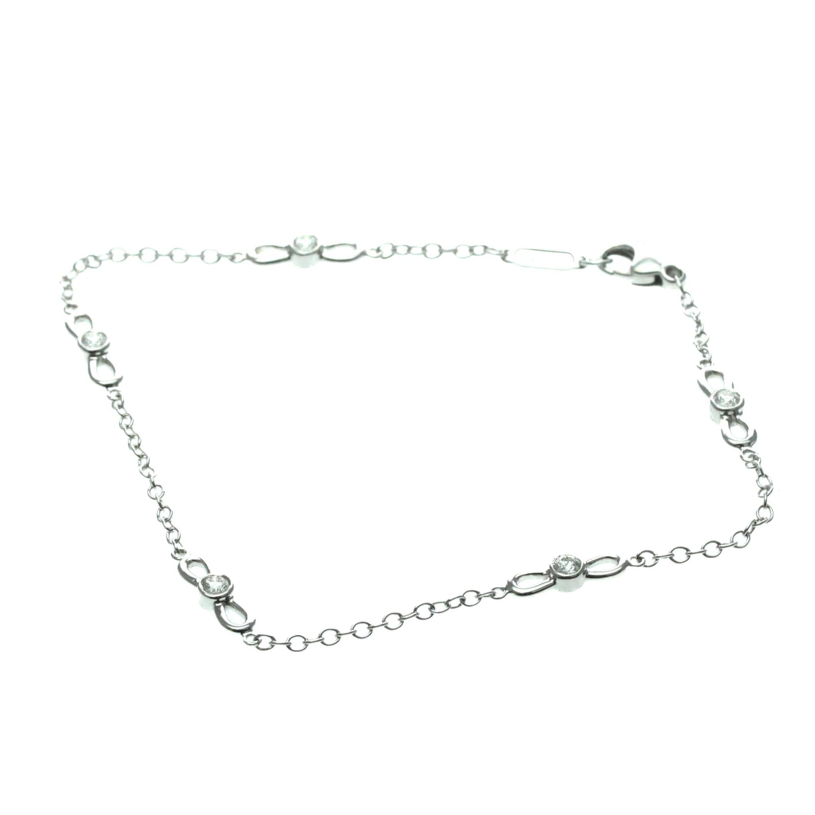 Tiffany Charm Bracelet White Gold (18K): Tiffany Charm Bracelet White Gold (18K) Tiffany's iconic ribbon diamond charm bracelet in white gold (18K) adds a touch of elegance to any outfit. Featuring diamonds set on a slender chain, this fashi