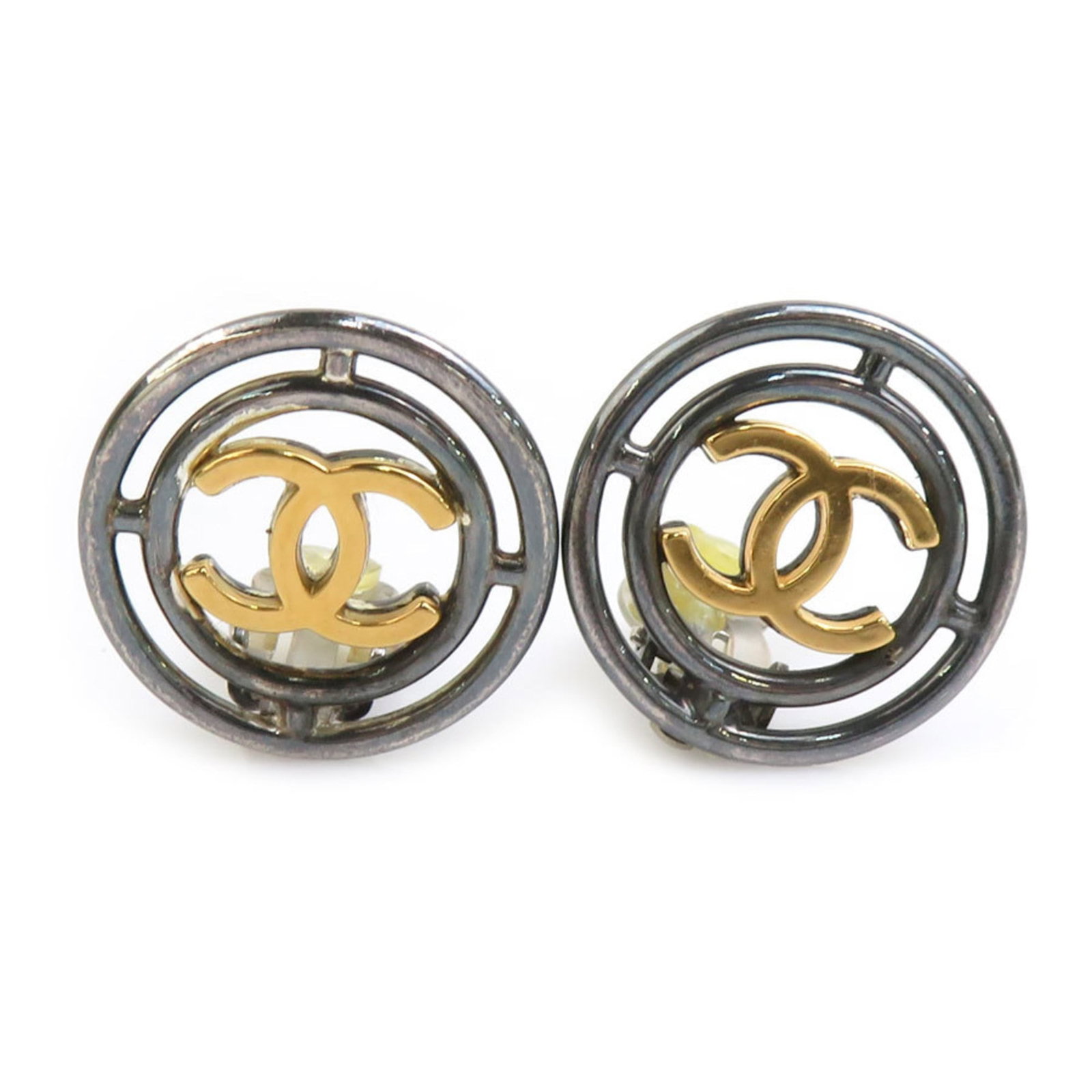Metal clip earrings by Chanel: Metal clip earrings by Chanel Metal clip earrings by Chanel, crafted from gold and gunmetal, feature a sleek design with a diameter of 23mm. The French brand's signature style shines through in these