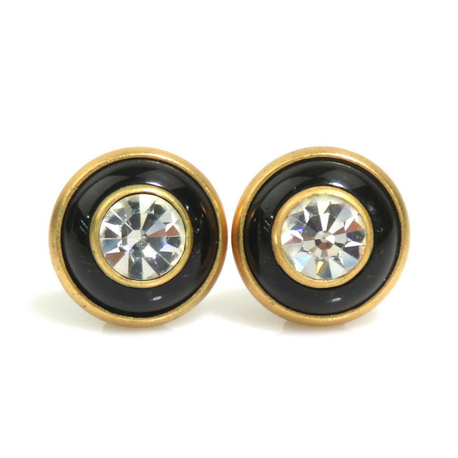 Rhinestone metal clip earrings by Chanel: Rhinestone metal clip earrings by Chanel Metal clip earrings by Chanel feature rhinestones in black, clear, and gold hues. The French design showcases a sleek, modern aesthetic with intricate metal