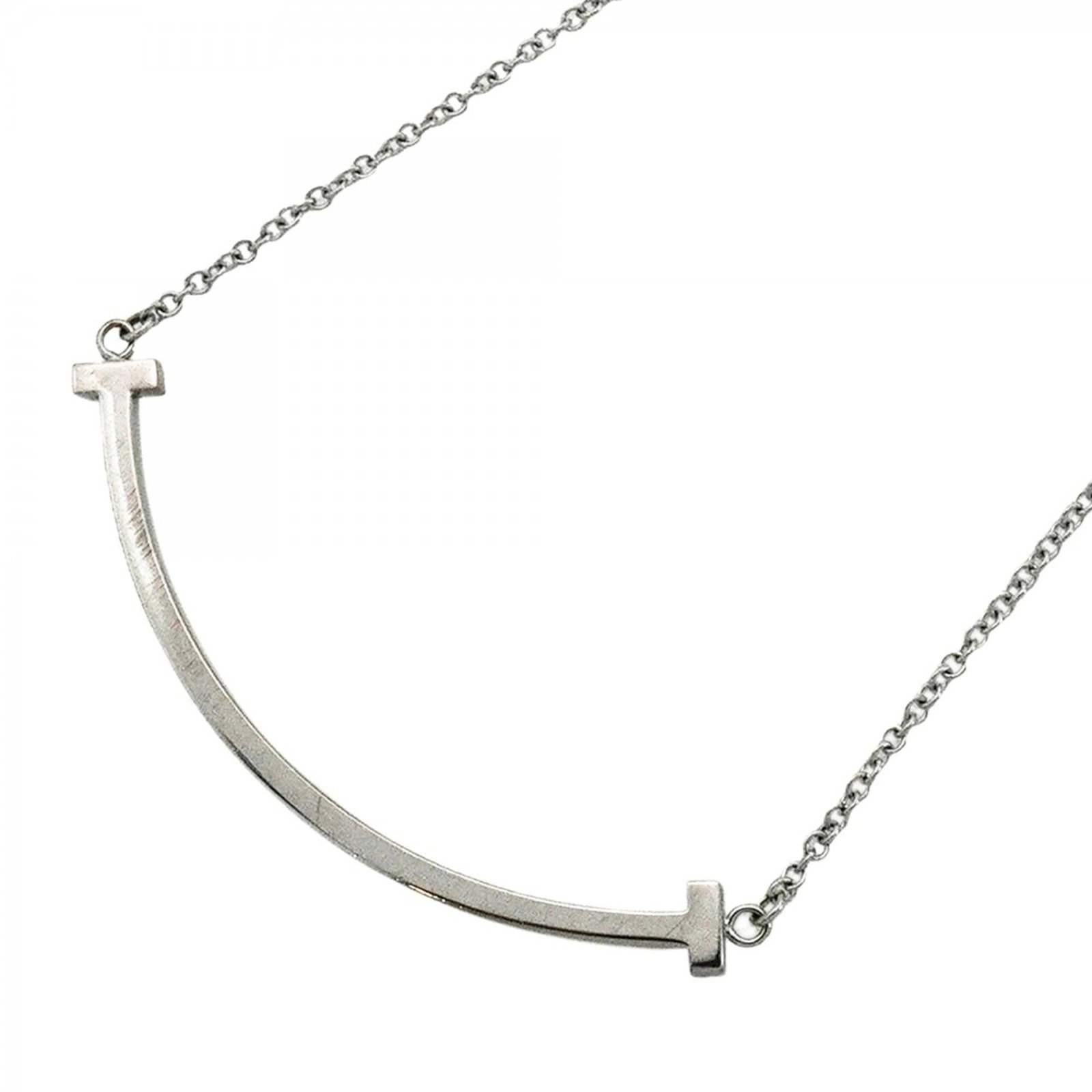 Tiffany and Co T Smile Small Women's 18K White Gold Necklace: Tiffany and Co T Smile Small Women's 18K White Gold Necklace Tiffany and Co's T Smile Small Women's 18K White Gold Necklace boasts elegant design with a pendant size of 9.8mm x 37.8mm, set against an 