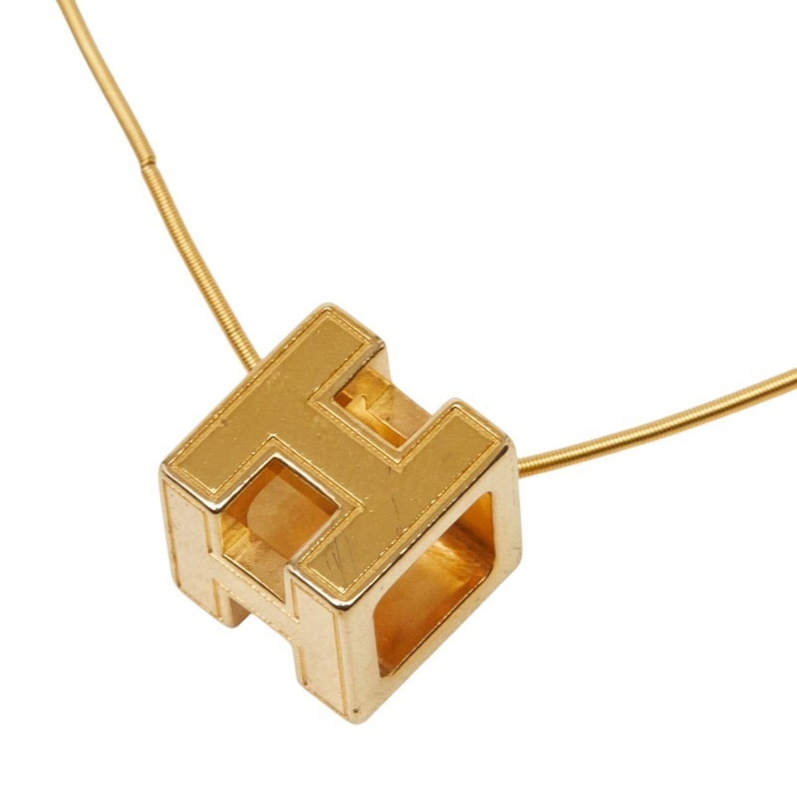 Women's gold plated cage d'h cube necklace from Hermes: Women's gold plated cage d'h cube necklace from Hermes Gold plated cage d'h cube necklace from Hermes features a striking gold pendant with a 12mm x 12mm design, suspended from a chain designed to